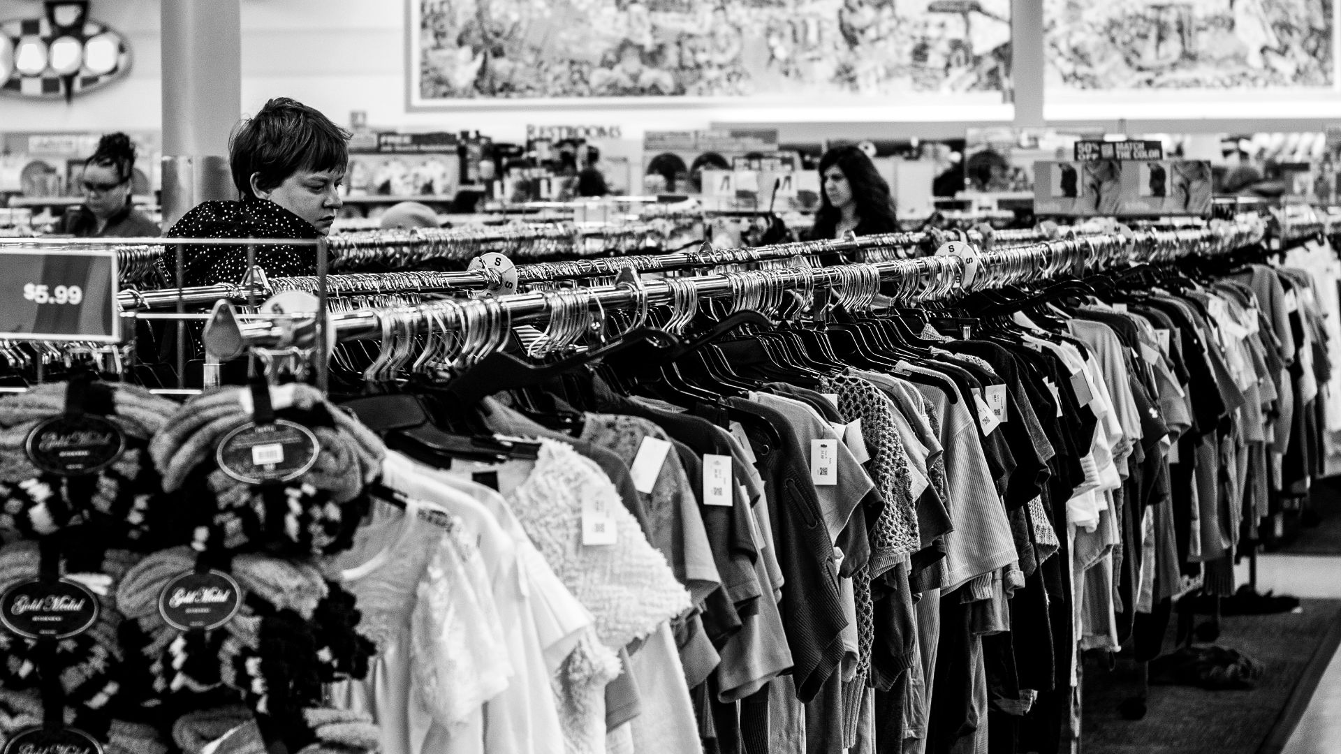 grayscale photography of people inside a clothing shop