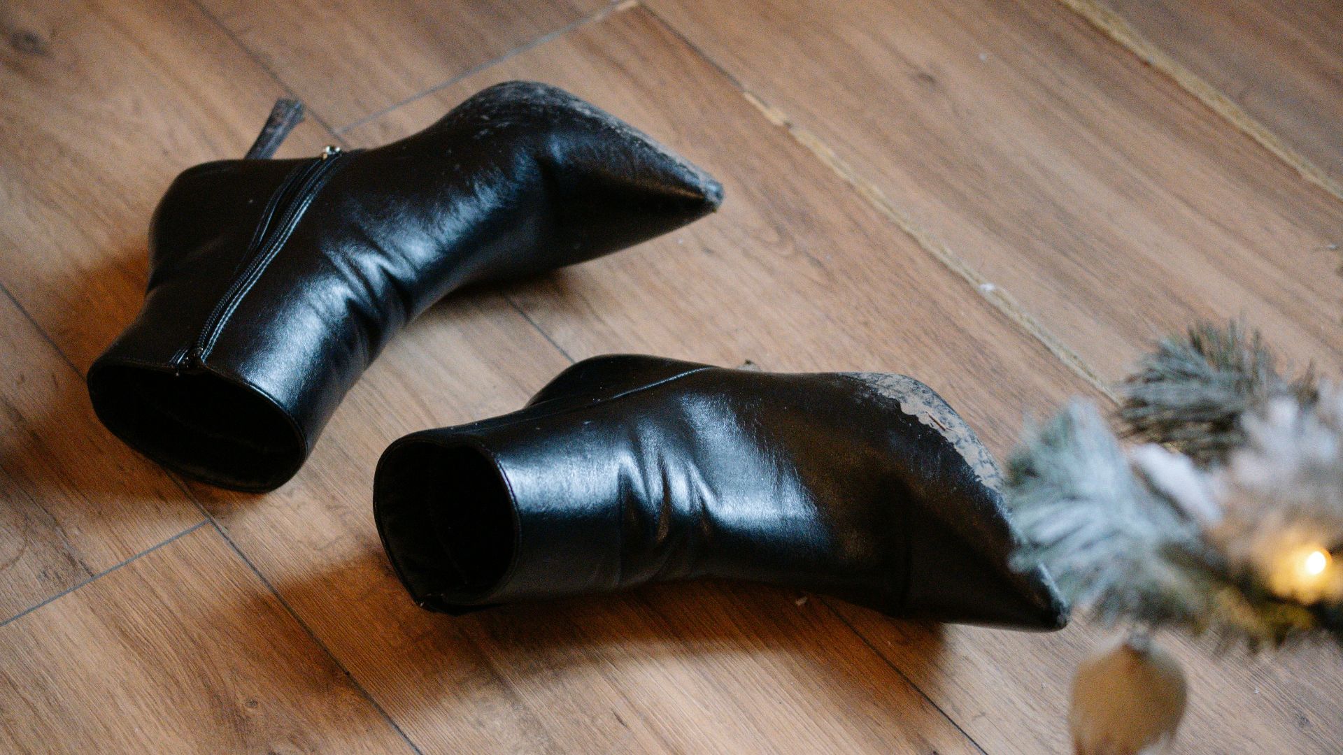 Black leather boots on a wooden floor.