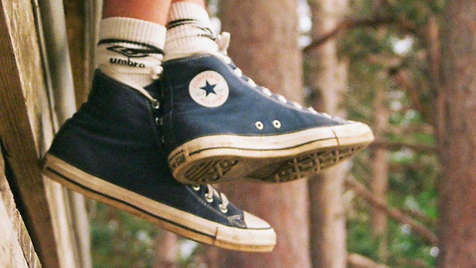 Person wearing blue high-top sneakers and brown pants outdoors.
