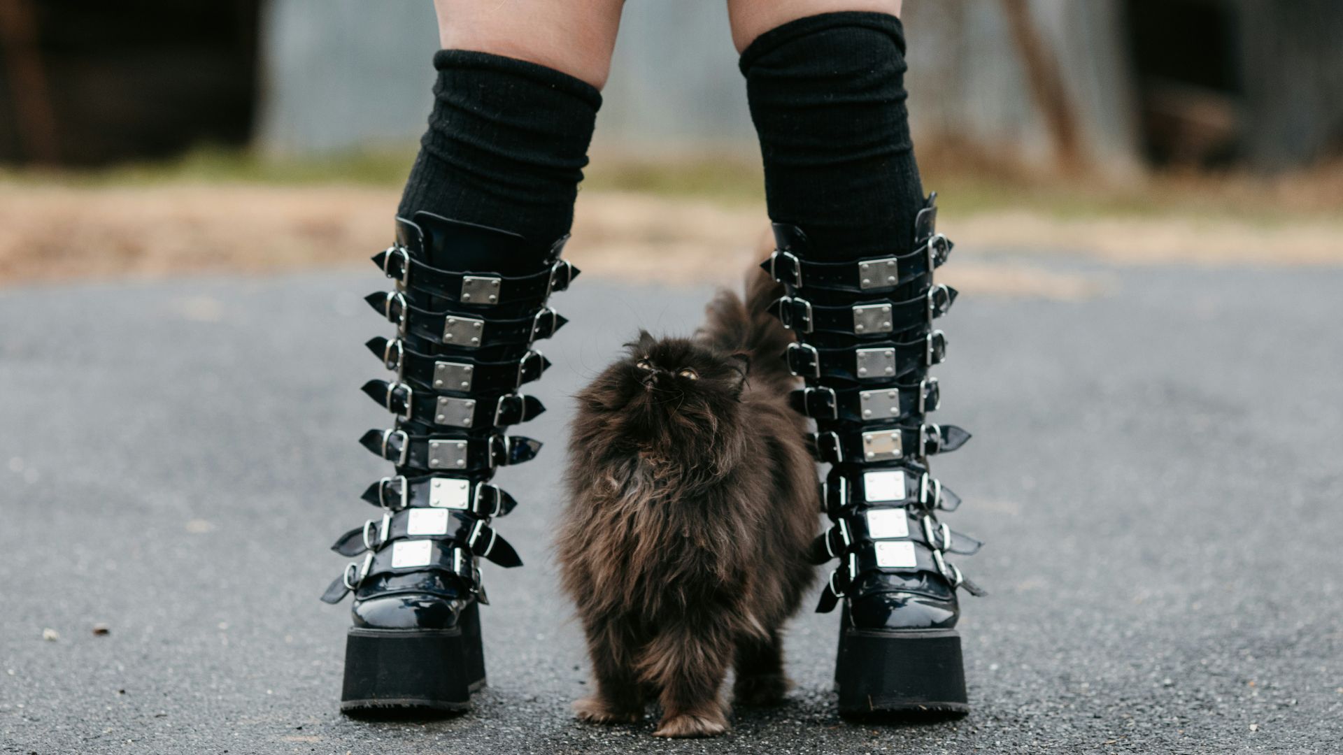 woman in black and white long sleeve shirt and black leggings wearing black boots walking on with on with on