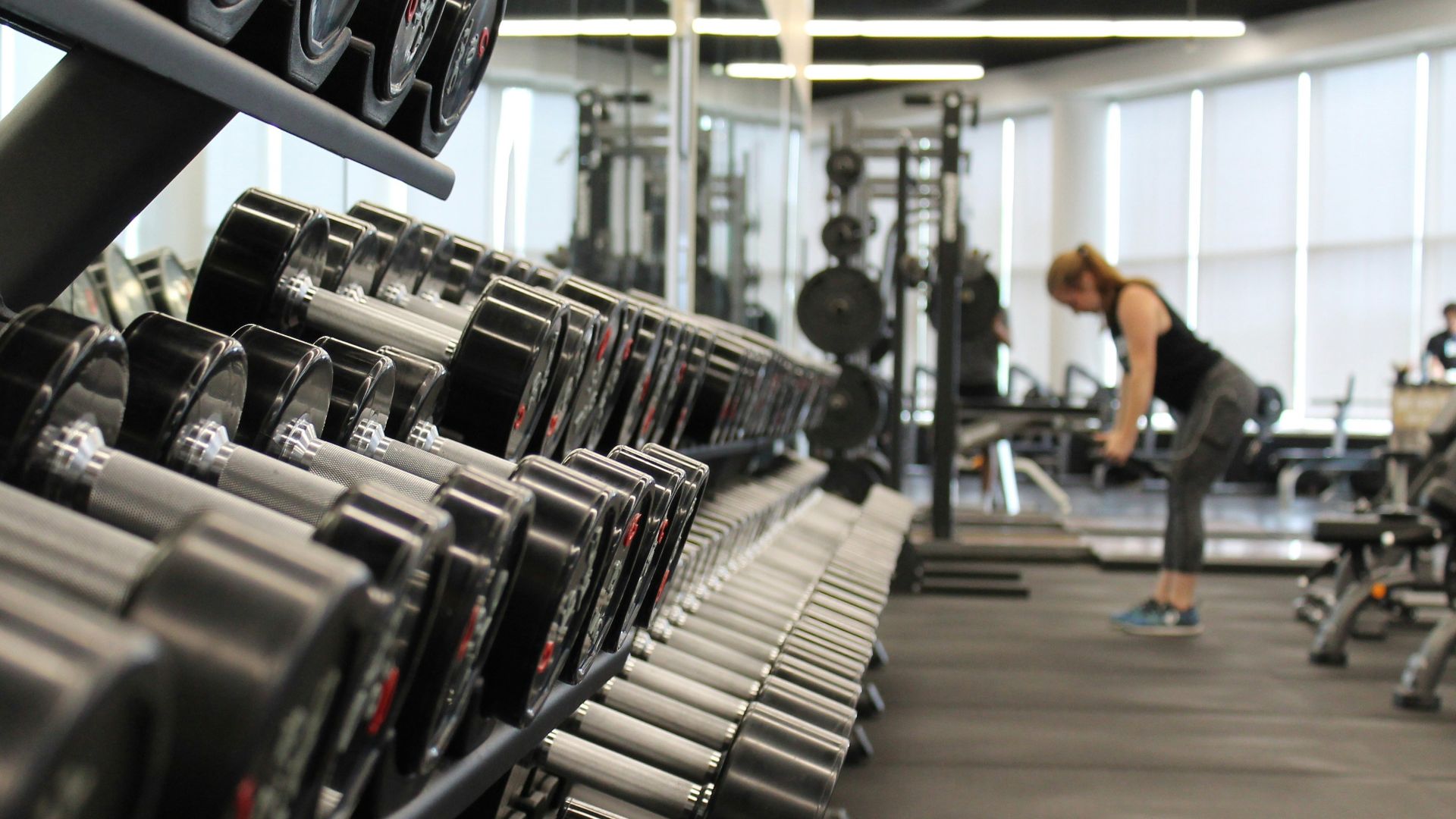 woman standing surrounded by exercise equipment