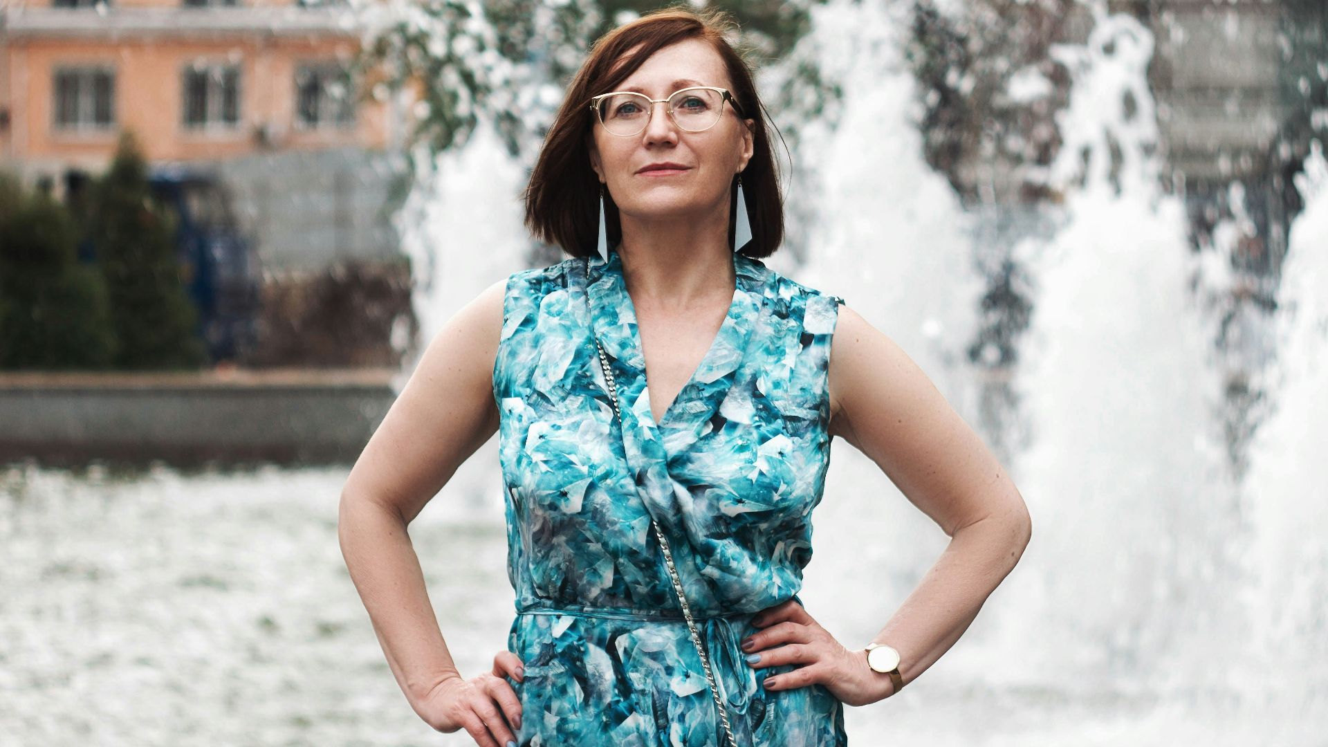 woman in blue and white floral sleeveless dress standing on snow covered ground during daytime