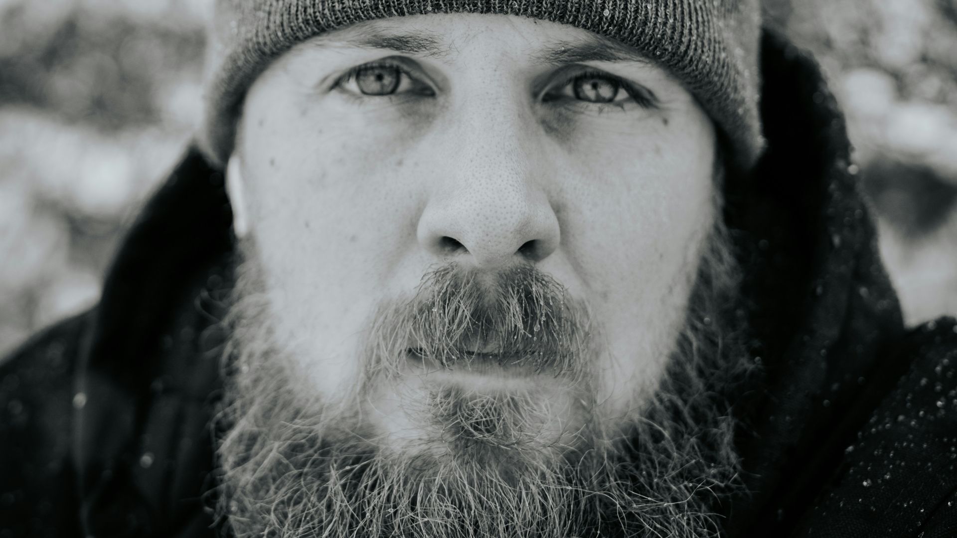 grayscale photography of man jacket and knit cap