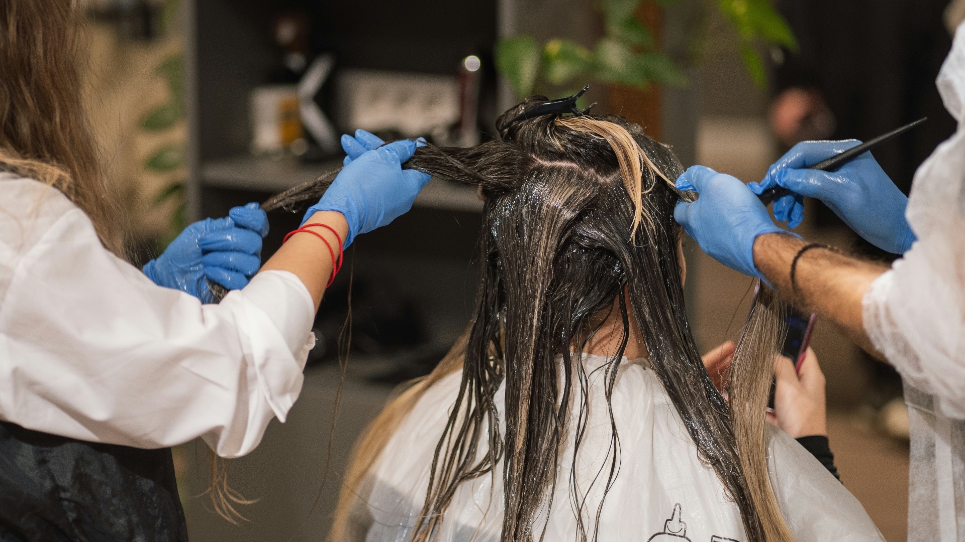 a woman getting her hair done by a hair stylist