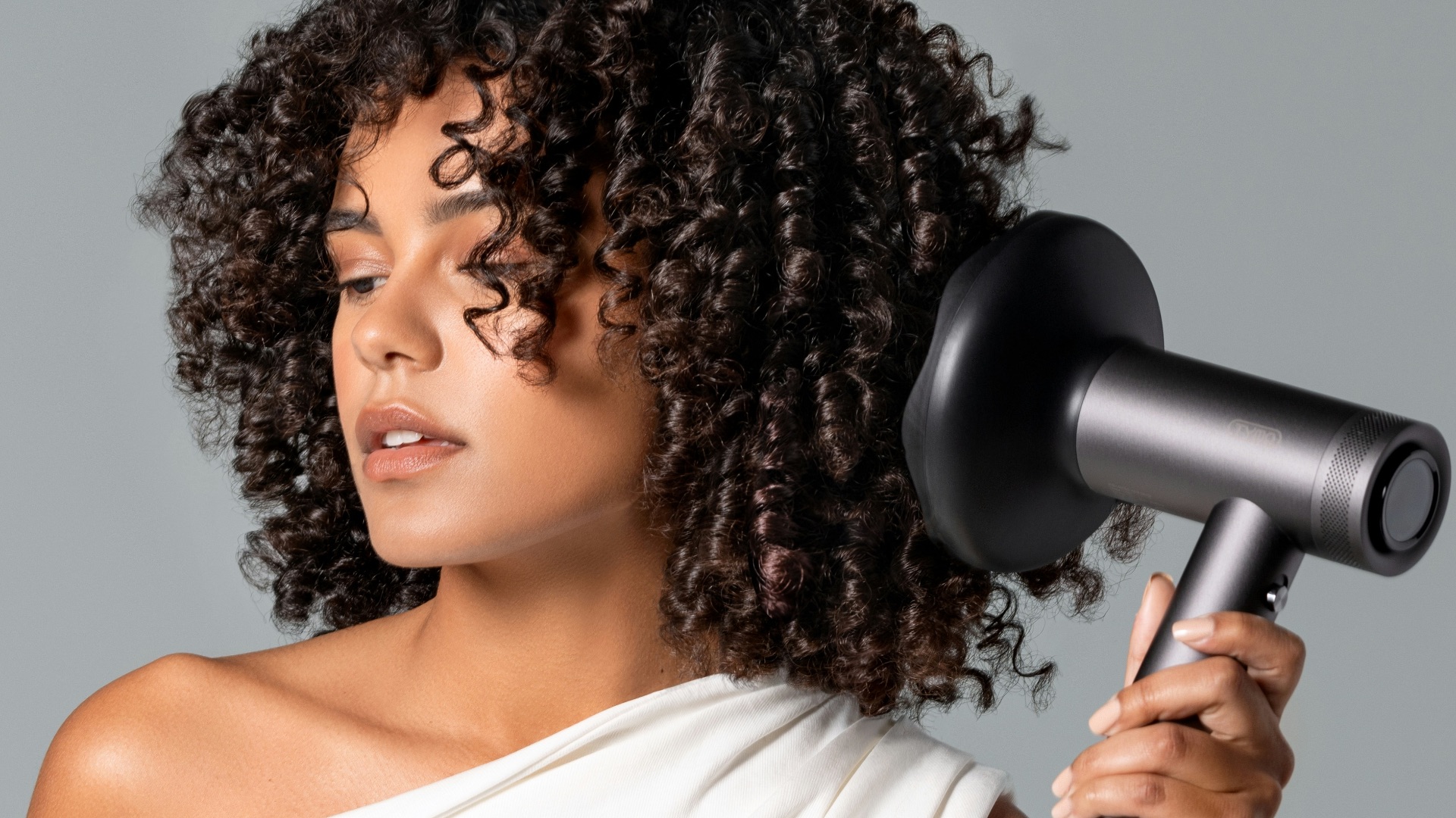 a woman blow drying her hair with a hair dryer
