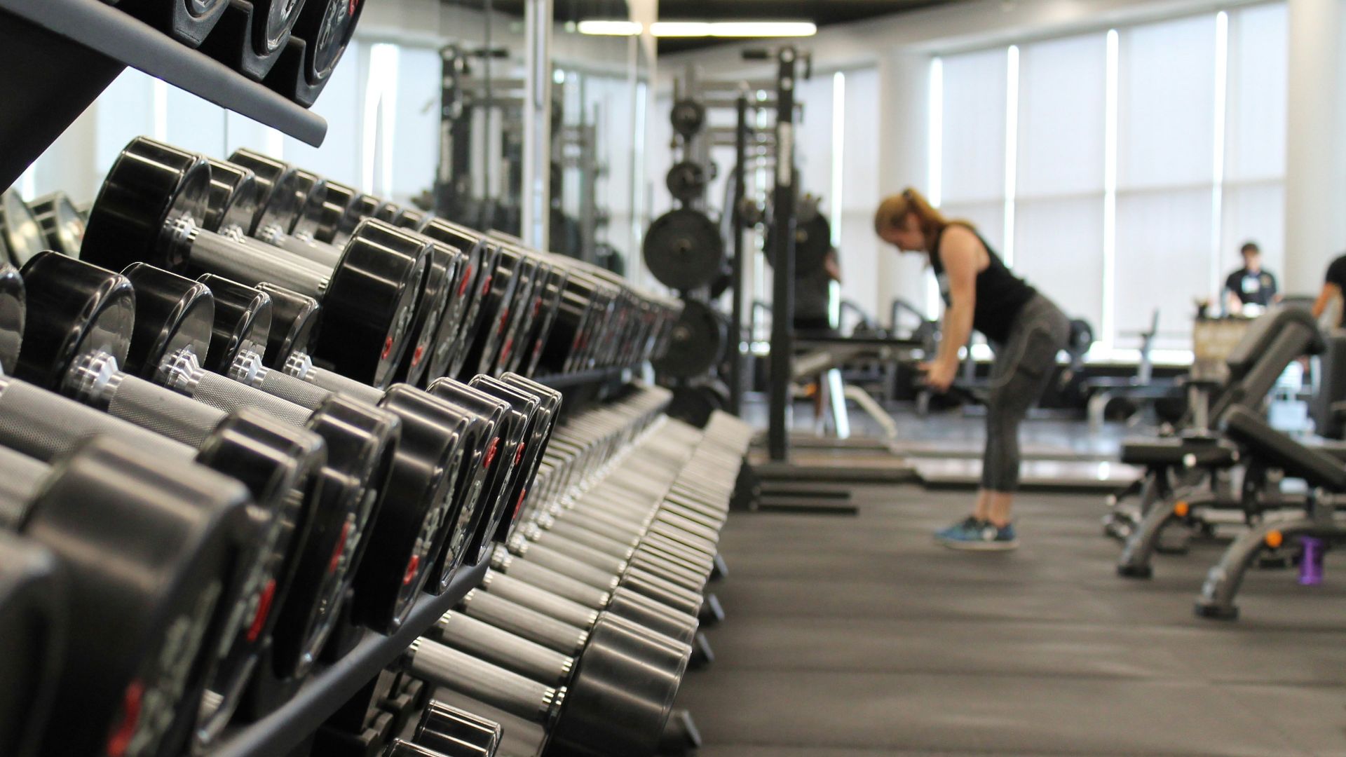 woman standing surrounded by exercise equipment