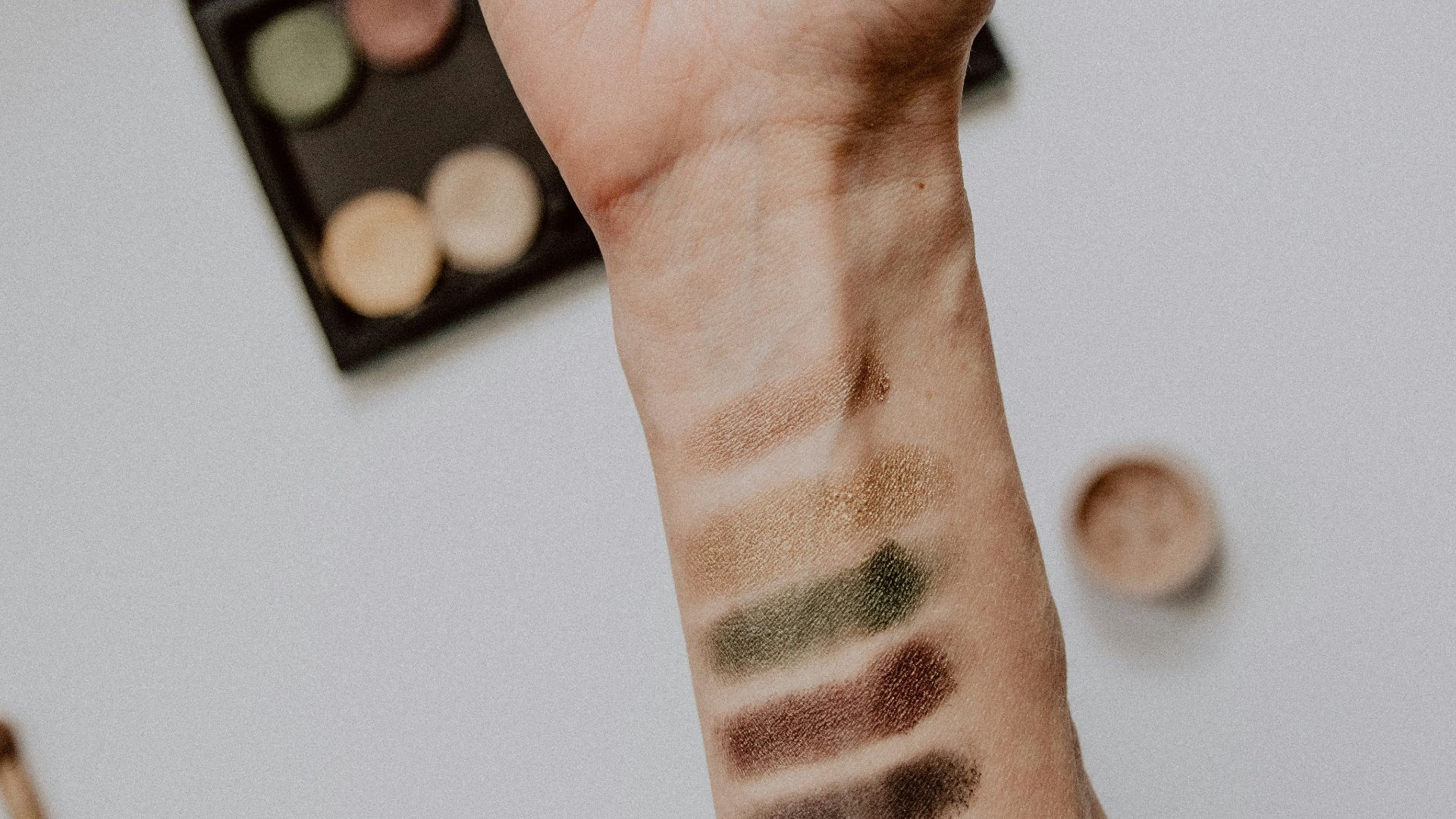 person with black and white tattoo on left hand