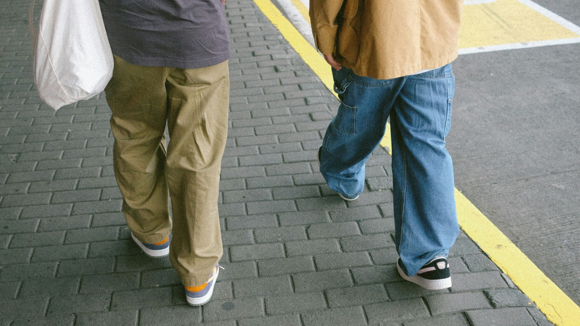 A couple of people walking down a street