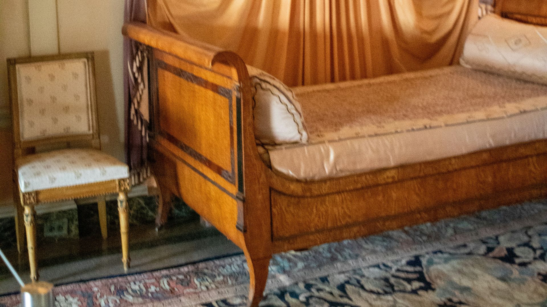 A canopy bed in a room with a rug on the floor