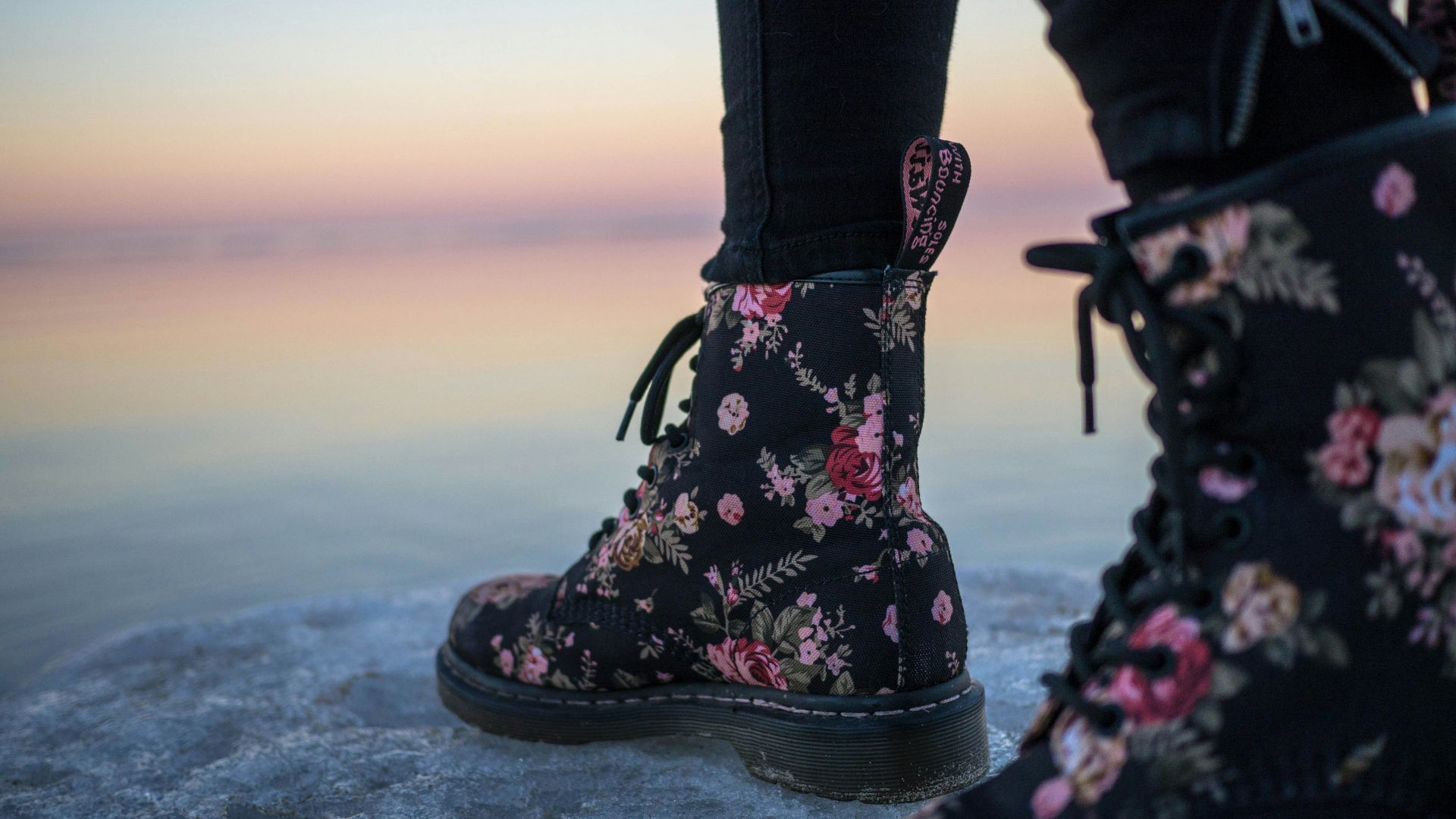 person wearing black and pink floral boots