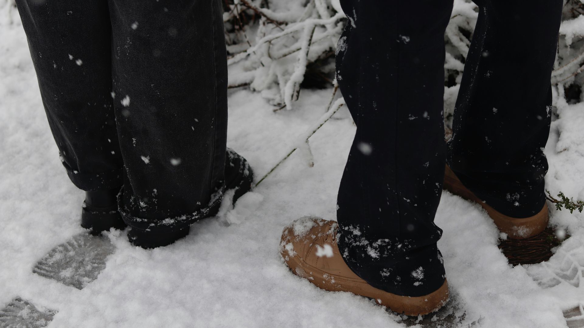 A person standing in the snow with their feet in the snow
