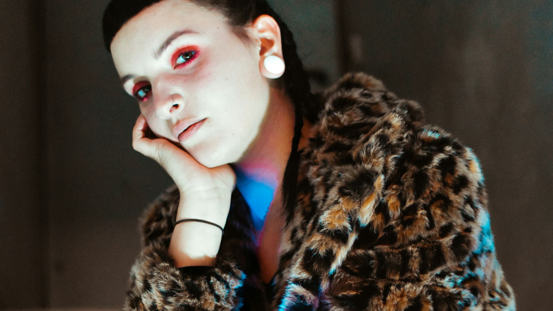 a woman in a leopard coat sitting on a step