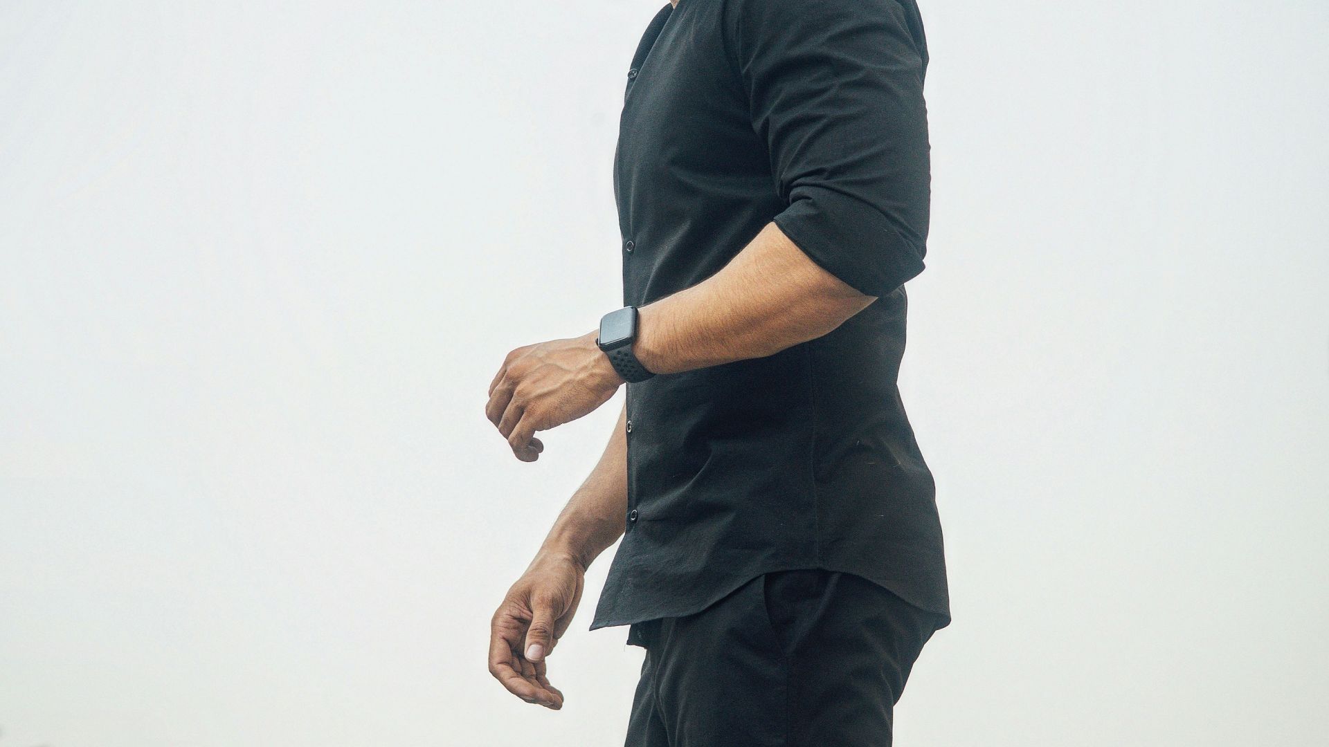 A man in black looks down.