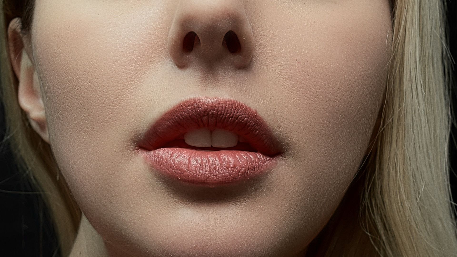 a woman with long blonde hair wearing a necklace