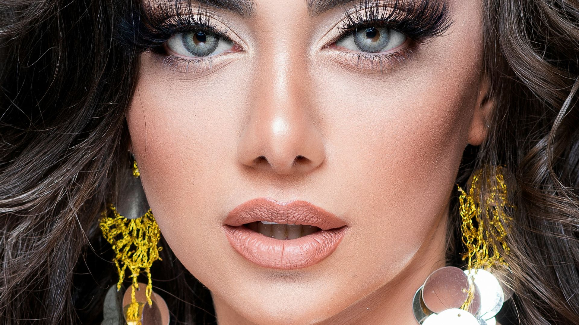 woman with black hair and wearing silver earrings