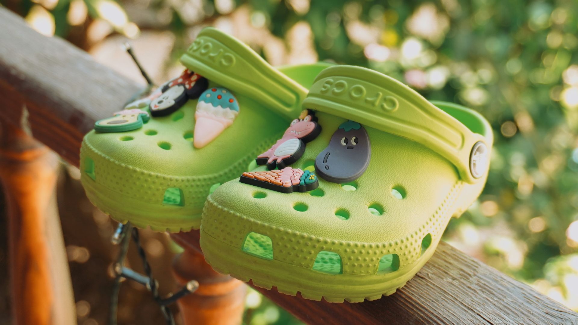 A pair of green shoes sitting on top of a wooden rail