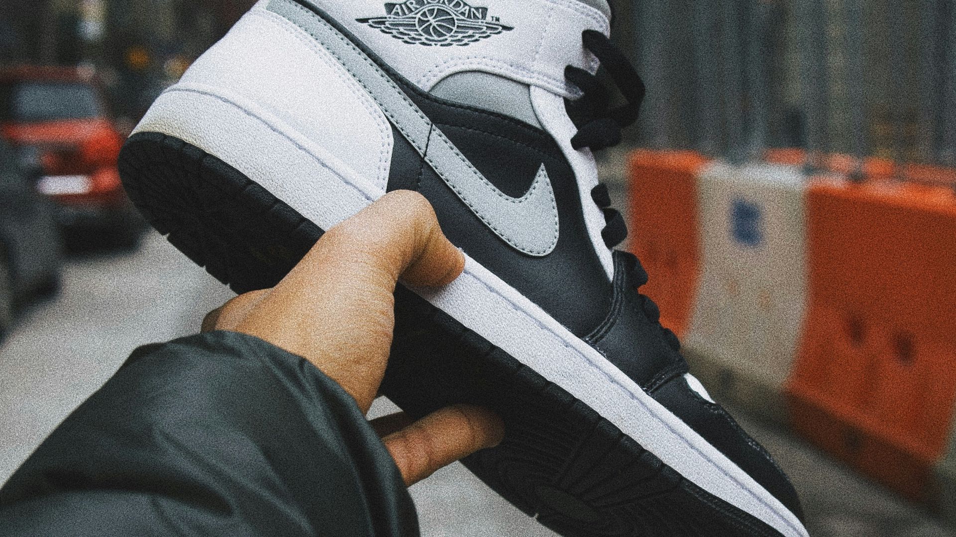 person holding white and black nike basketball shoes