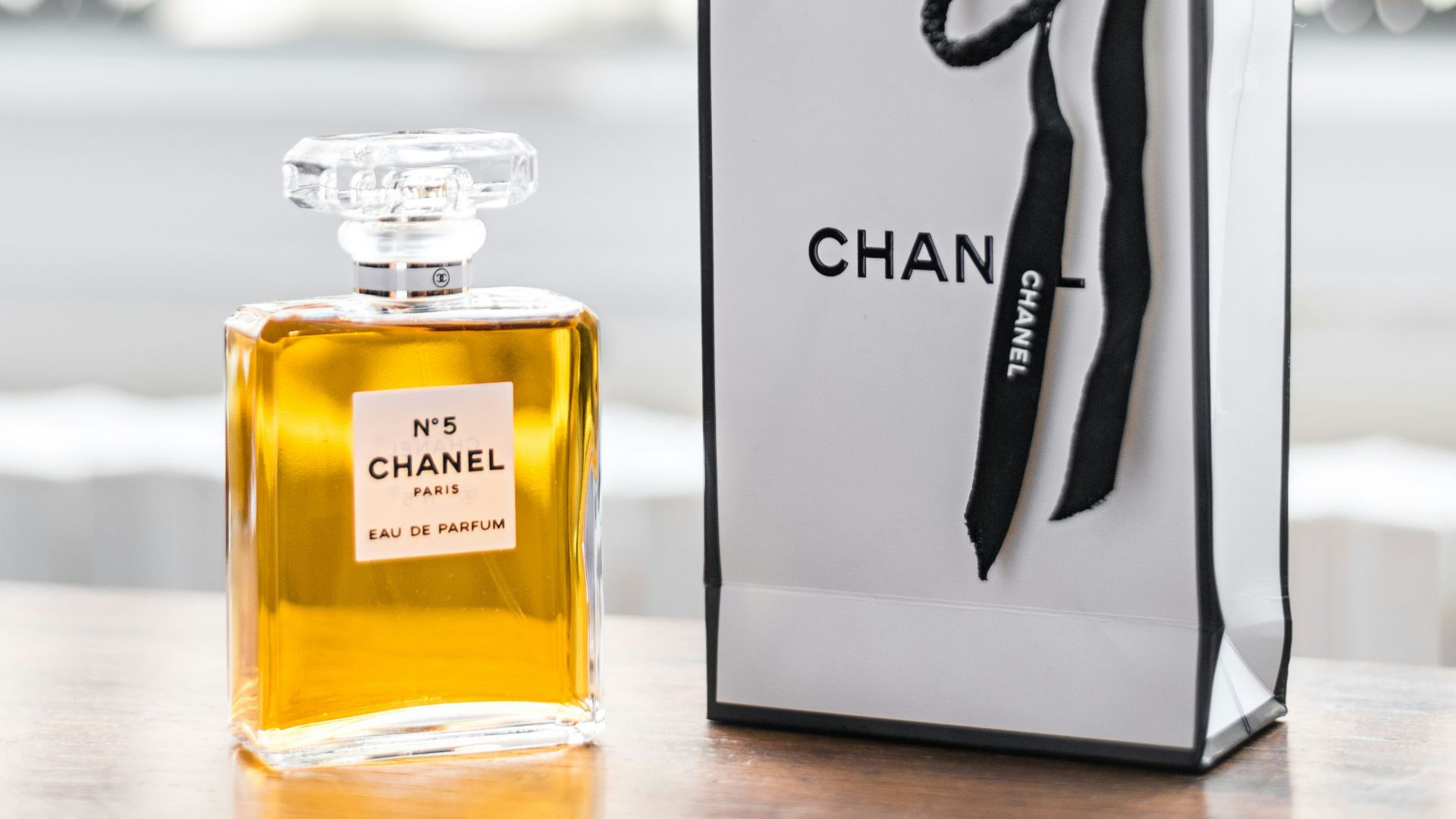 a bottle of chanel on a table next to a bag