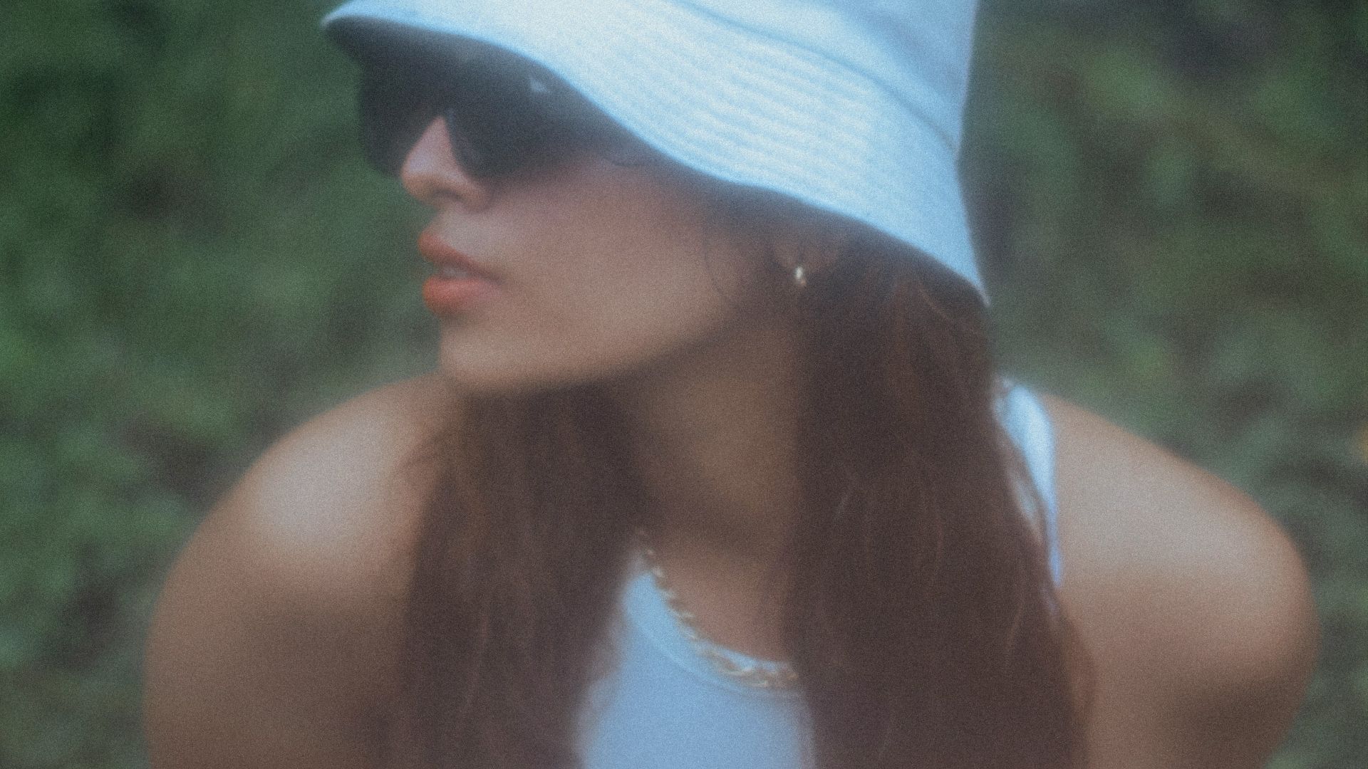a woman wearing a white hat and sunglasses