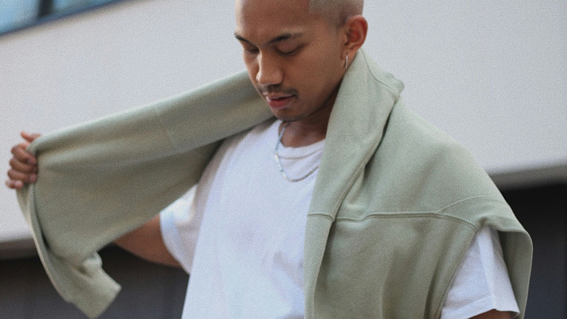 man in white polo shirt and blue denim jeans holding white textile