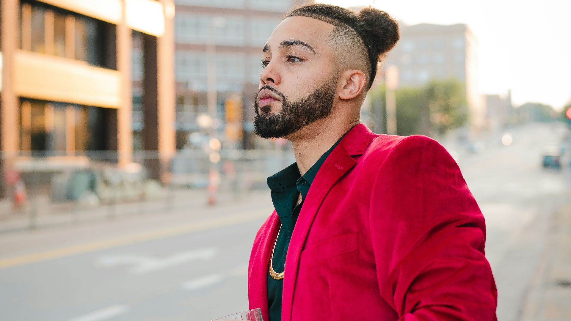 man in red coat standing on road during daytime