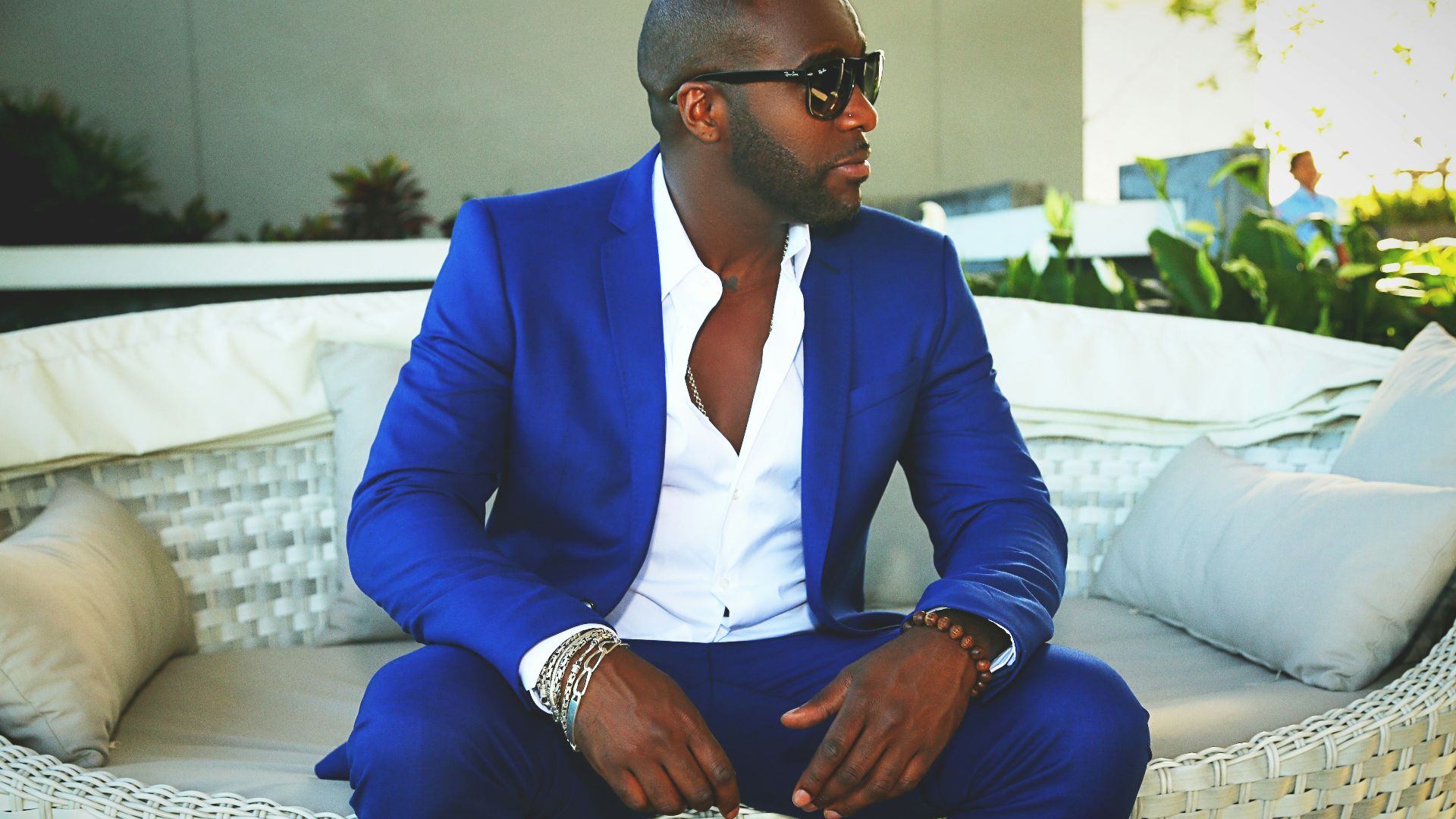 man in blue suit sitting on white couch