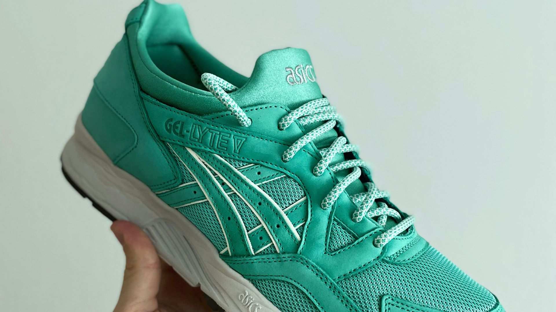 person holding green nike athletic shoe