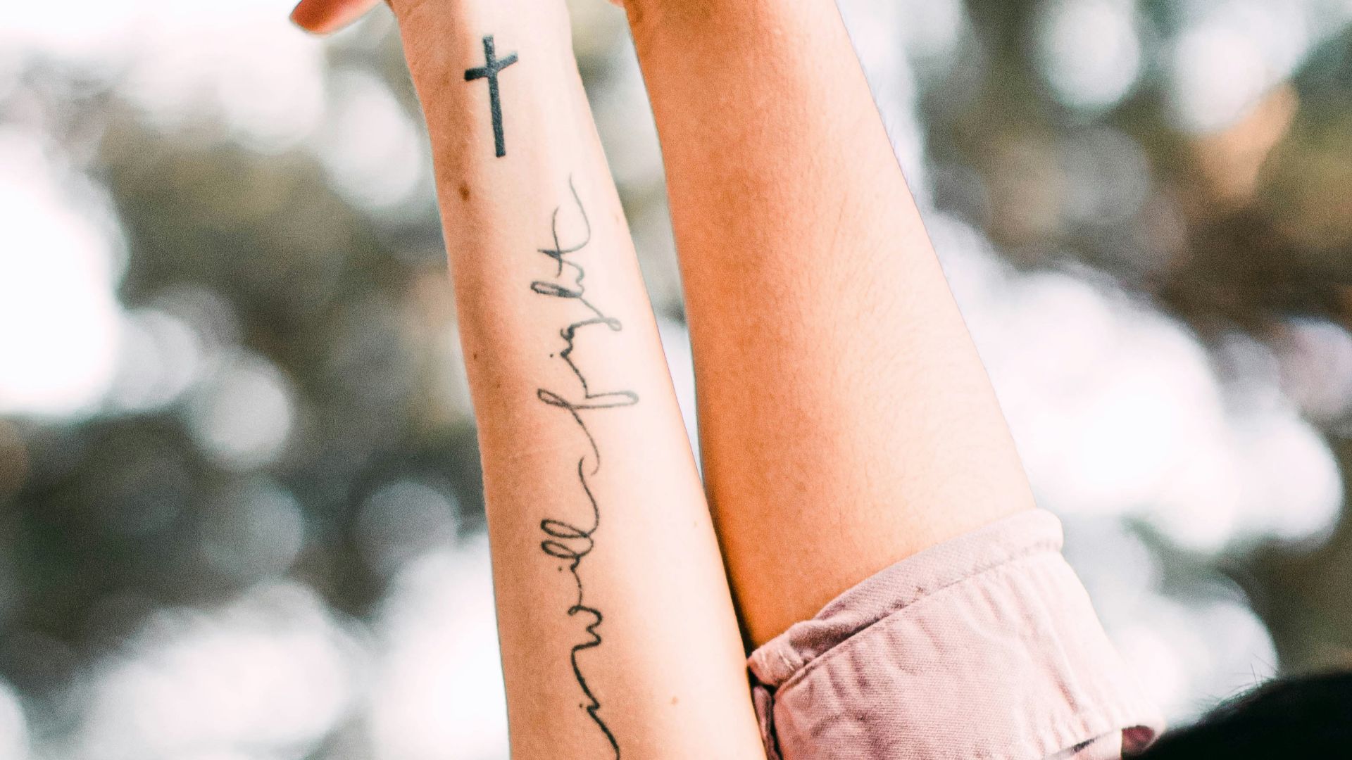 woman in black shirt with tattoo on her left arm