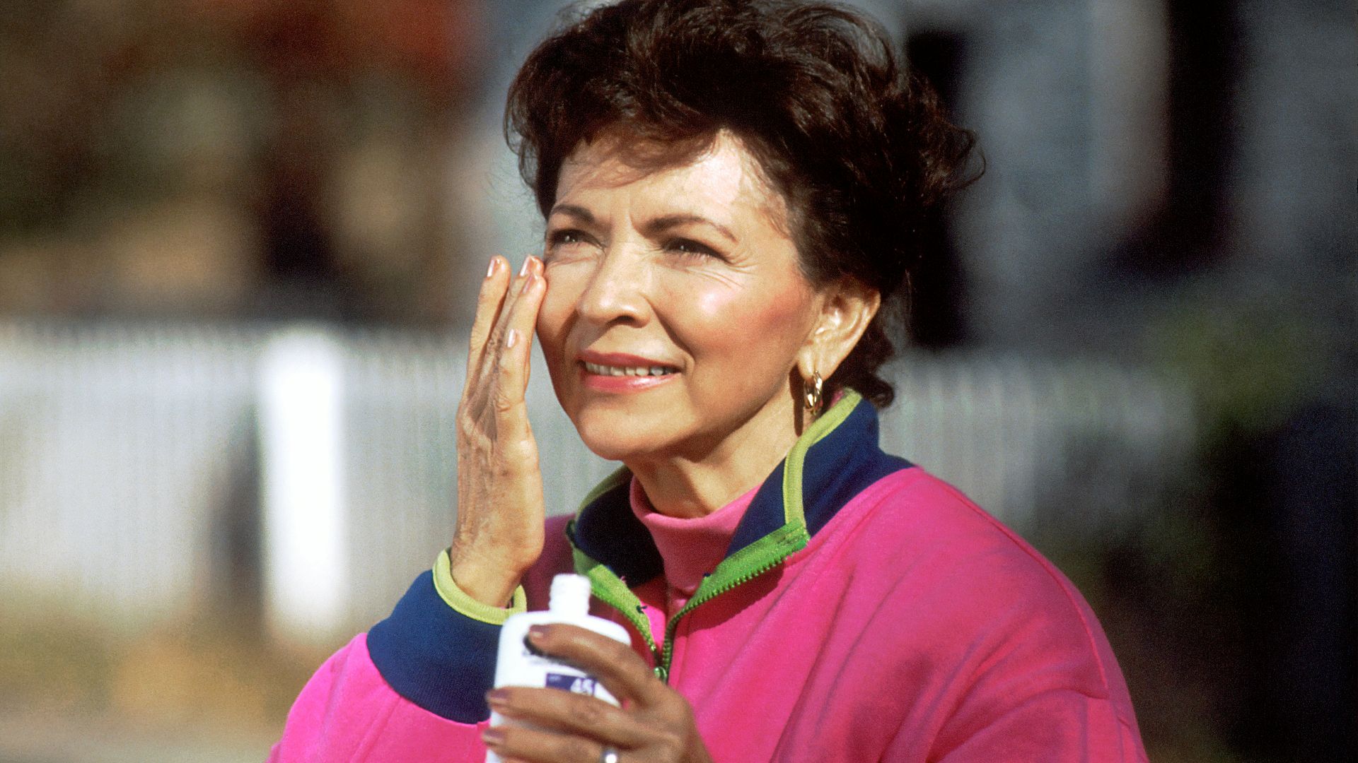 smiling woman in pink and blue shirt