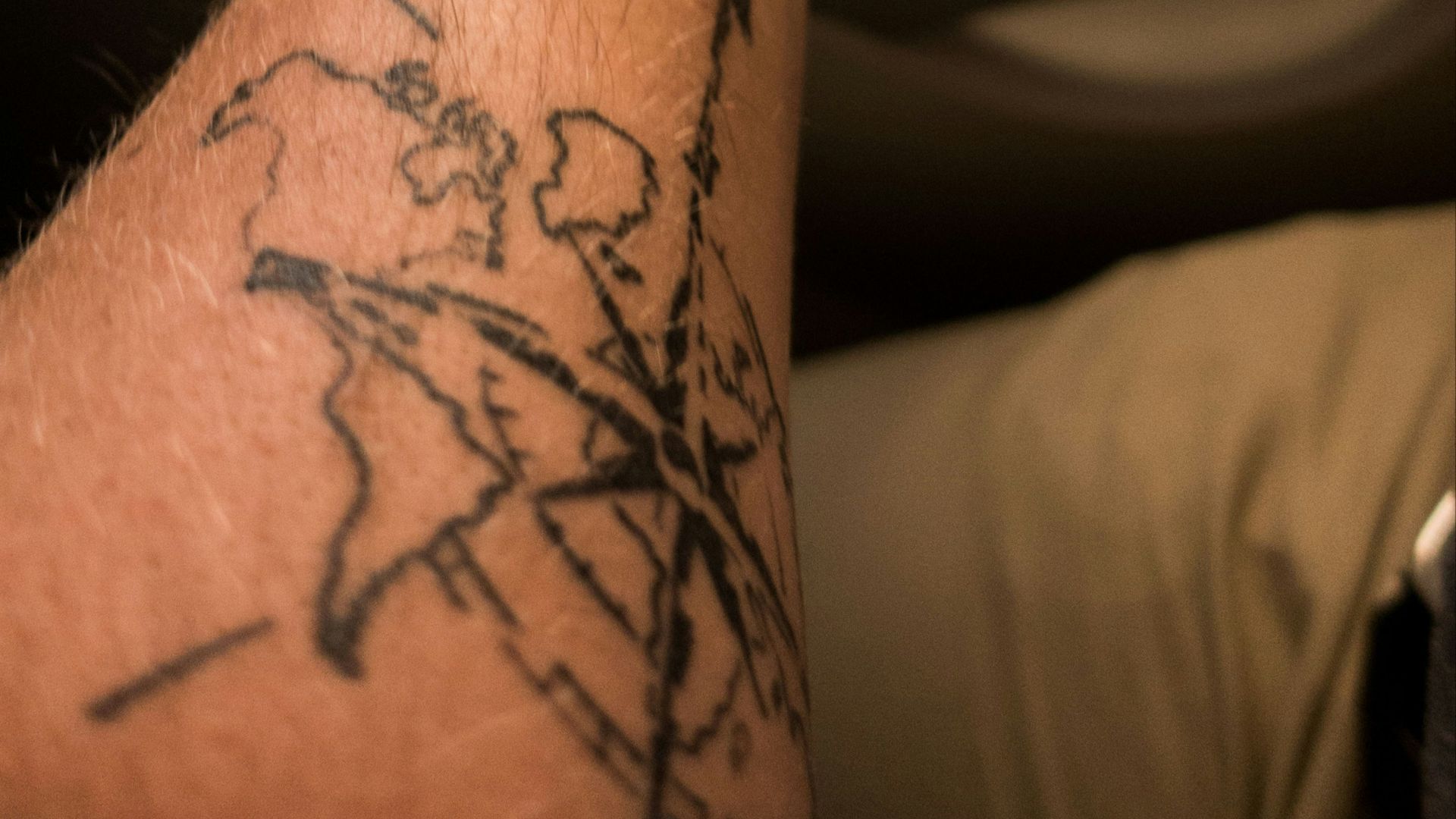 left person's arm with compass tattoo