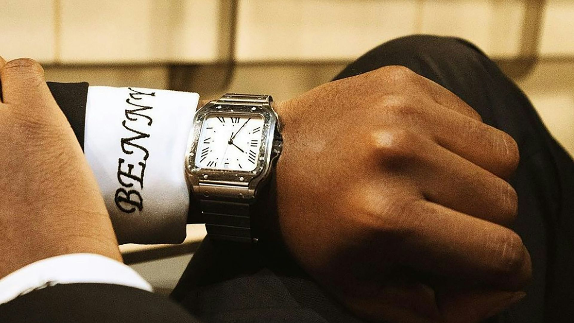 A man in a suit is holding onto a tie