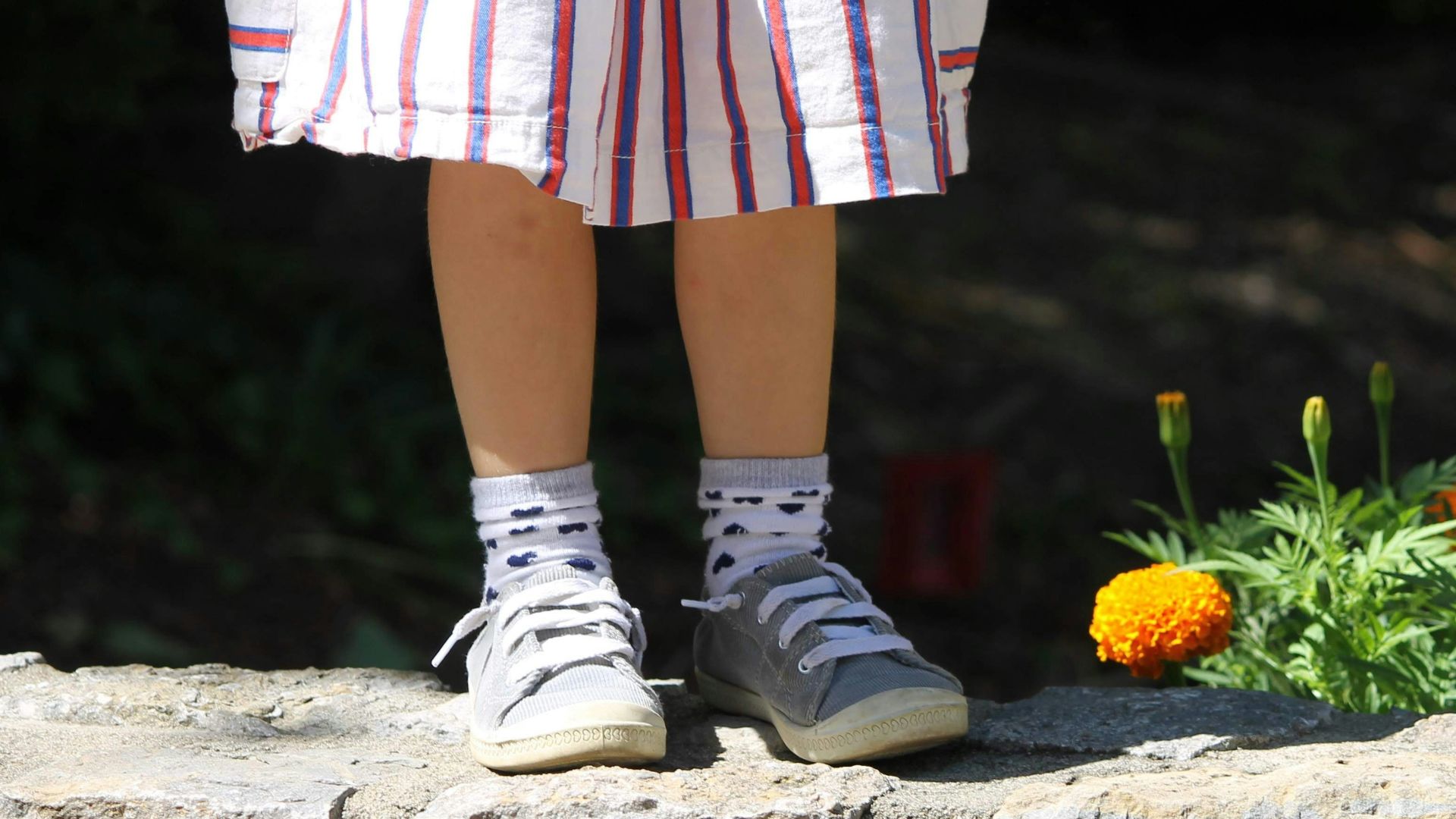 person in white sneakers standing on gray concrete blocks
