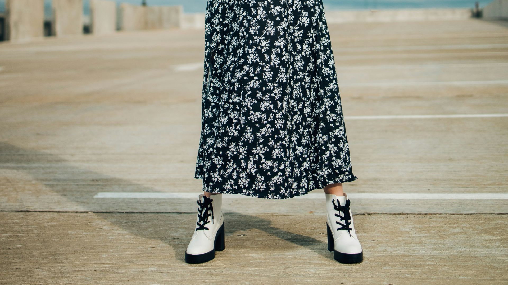 woman in black sleeveless dress standing on gray concrete road during daytime