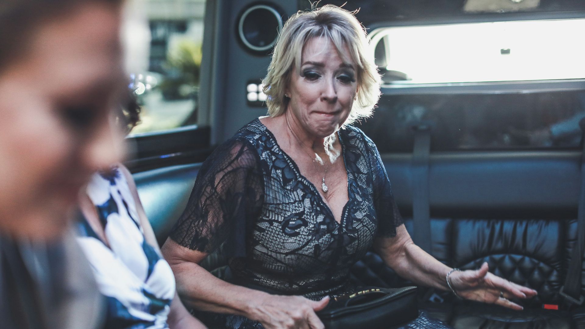 woman in black and white floral dress sitting on black car