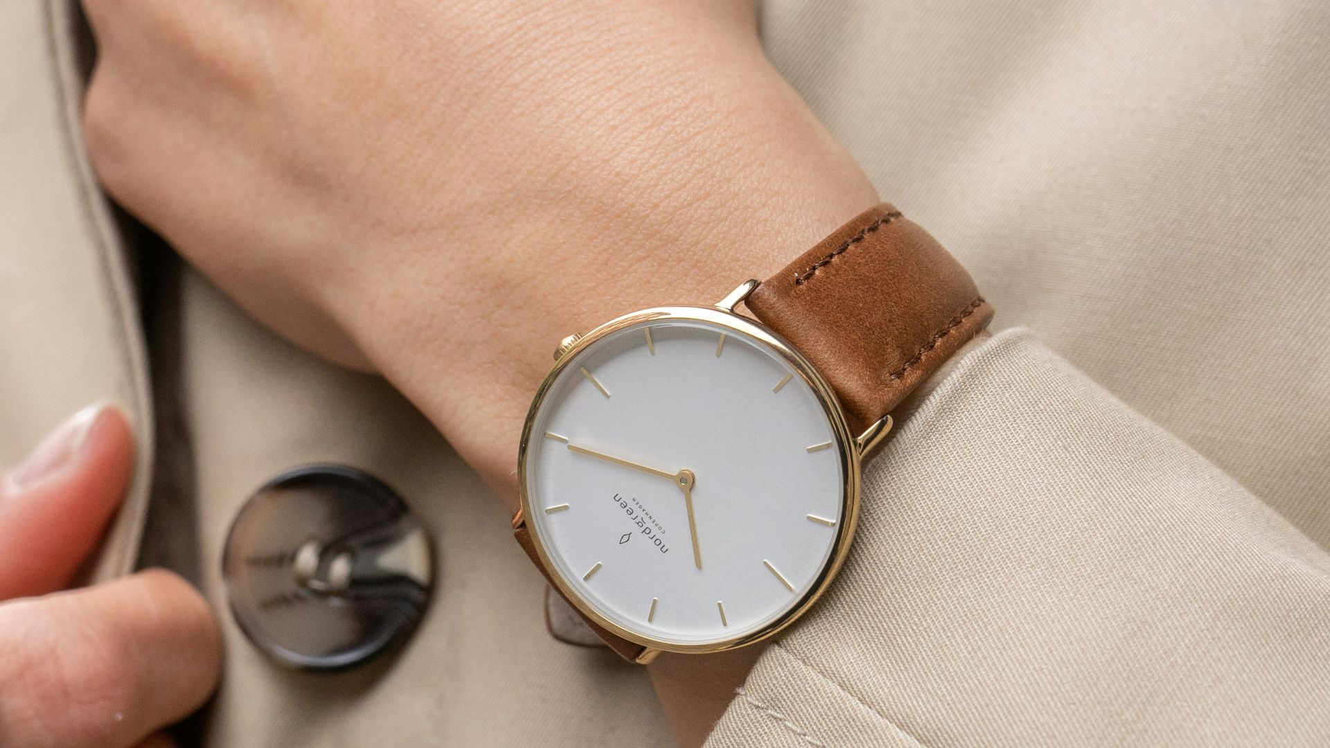 a woman wearing a trench coat and a watch