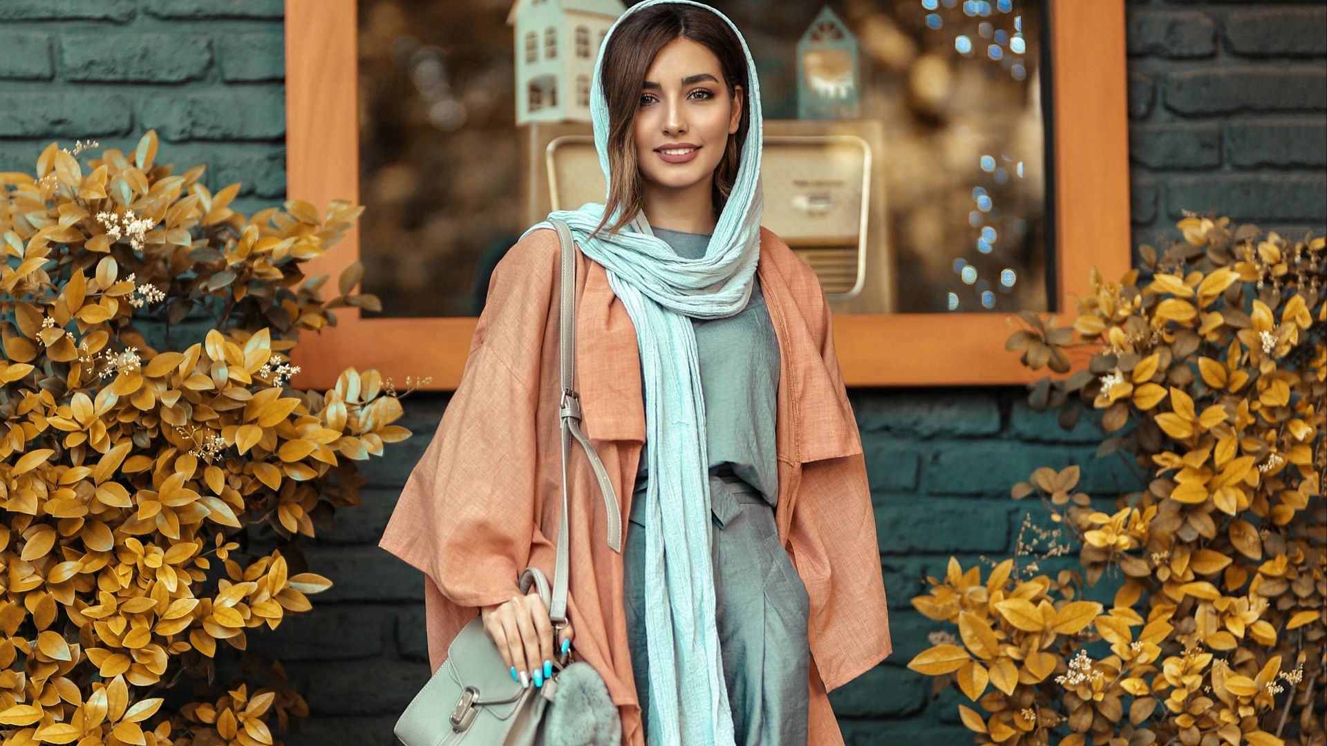 woman in blue and white long sleeve dress standing beside yellow flowers