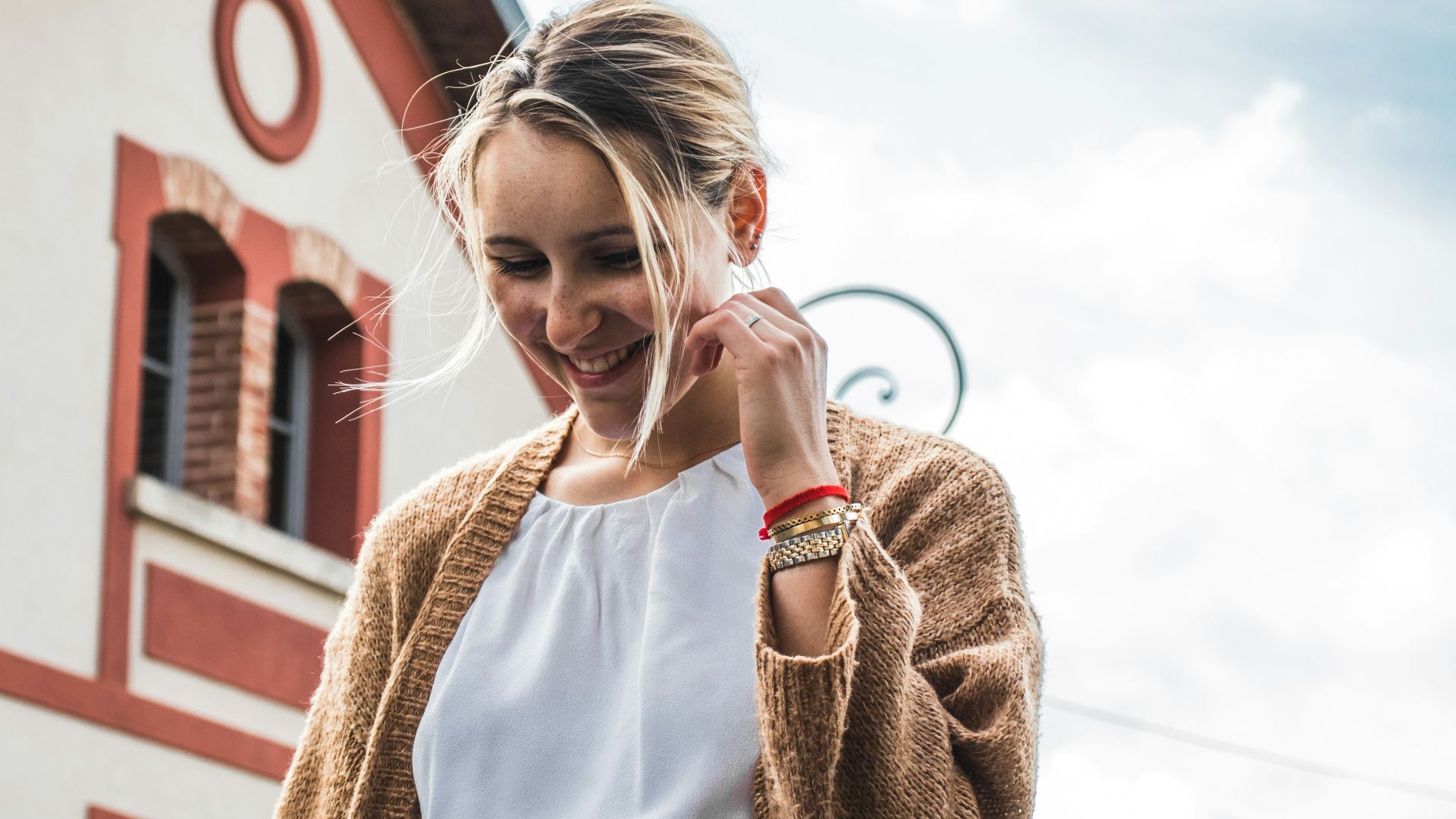 smiling woman standing near house