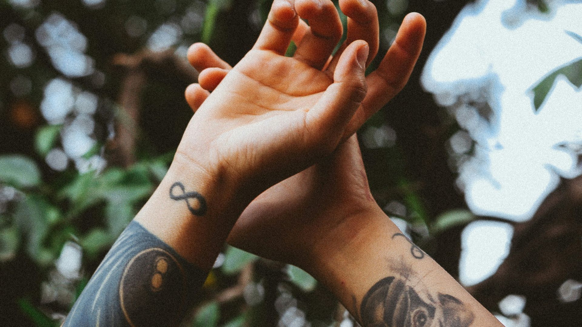 person raising his hands near tree