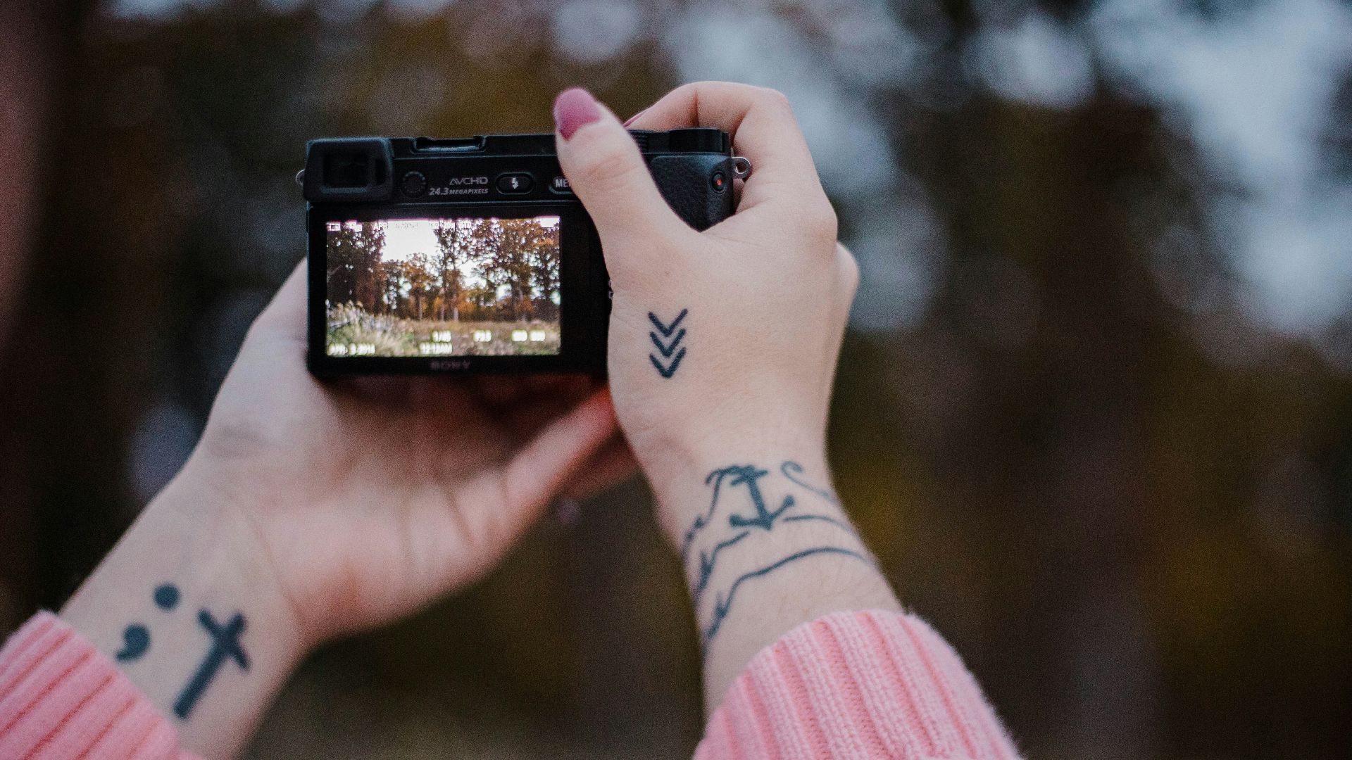 person holding black camera selective focus photography