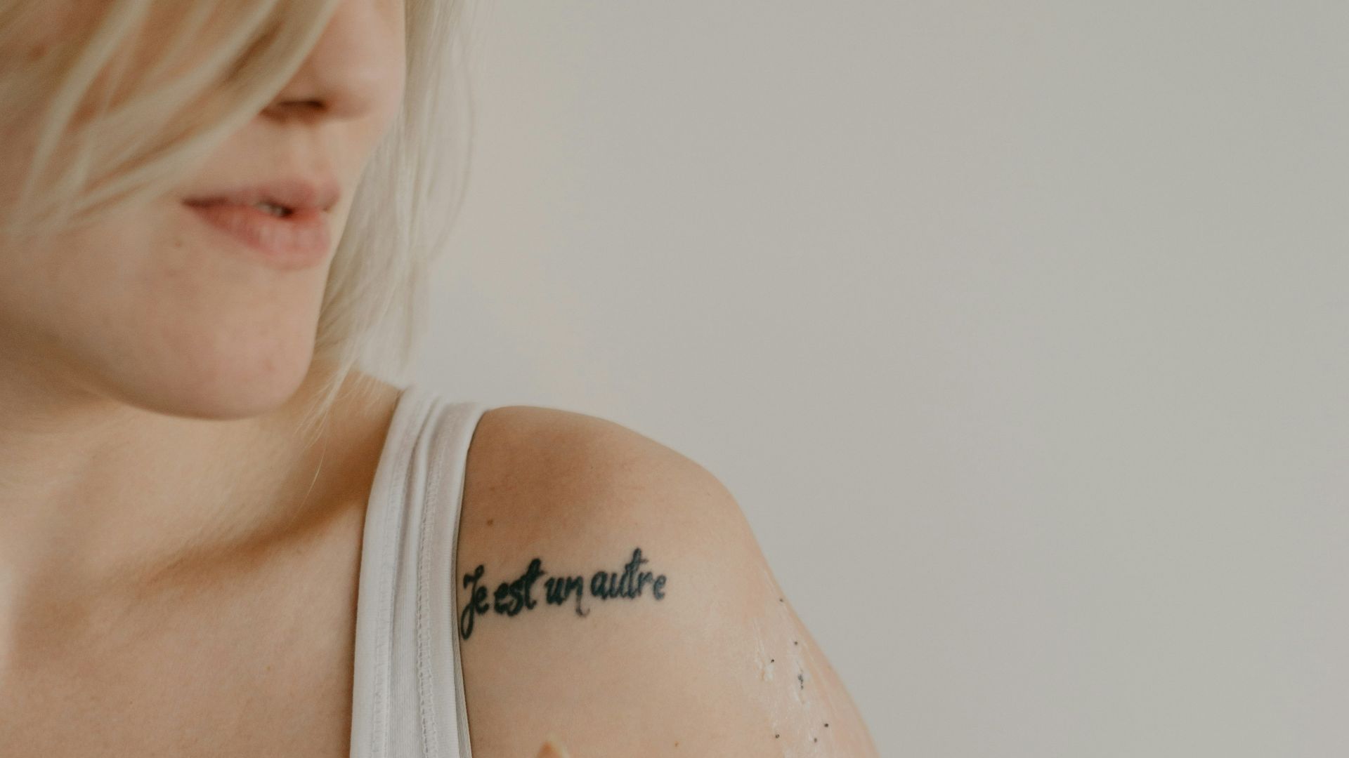 woman wearing white tank top while holding gray orgnament