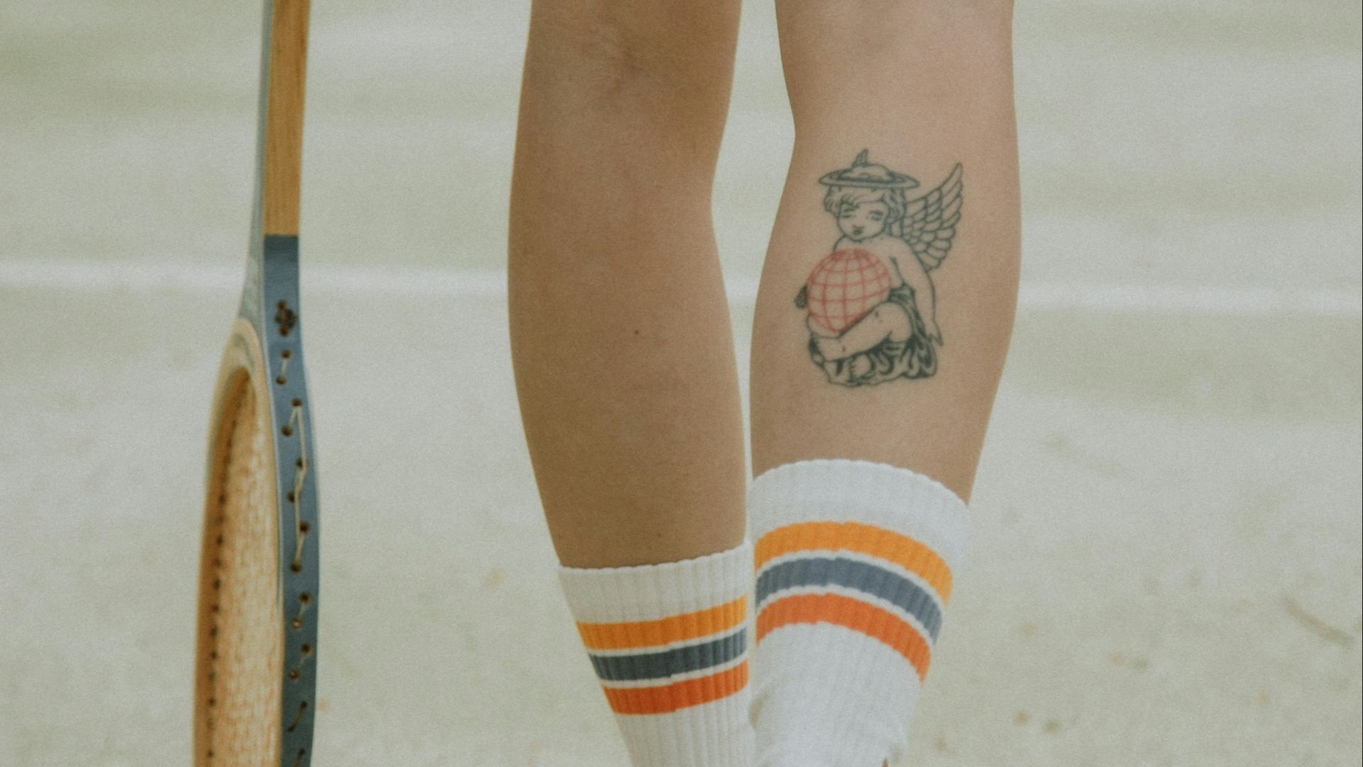 person in white socks and white socks with black and red star tattoo on right leg