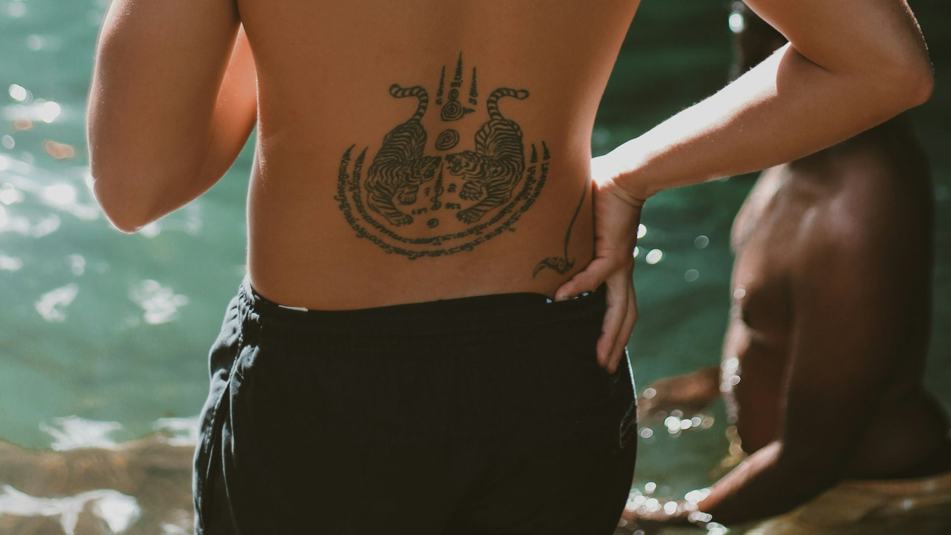 topless man with tattoo on back