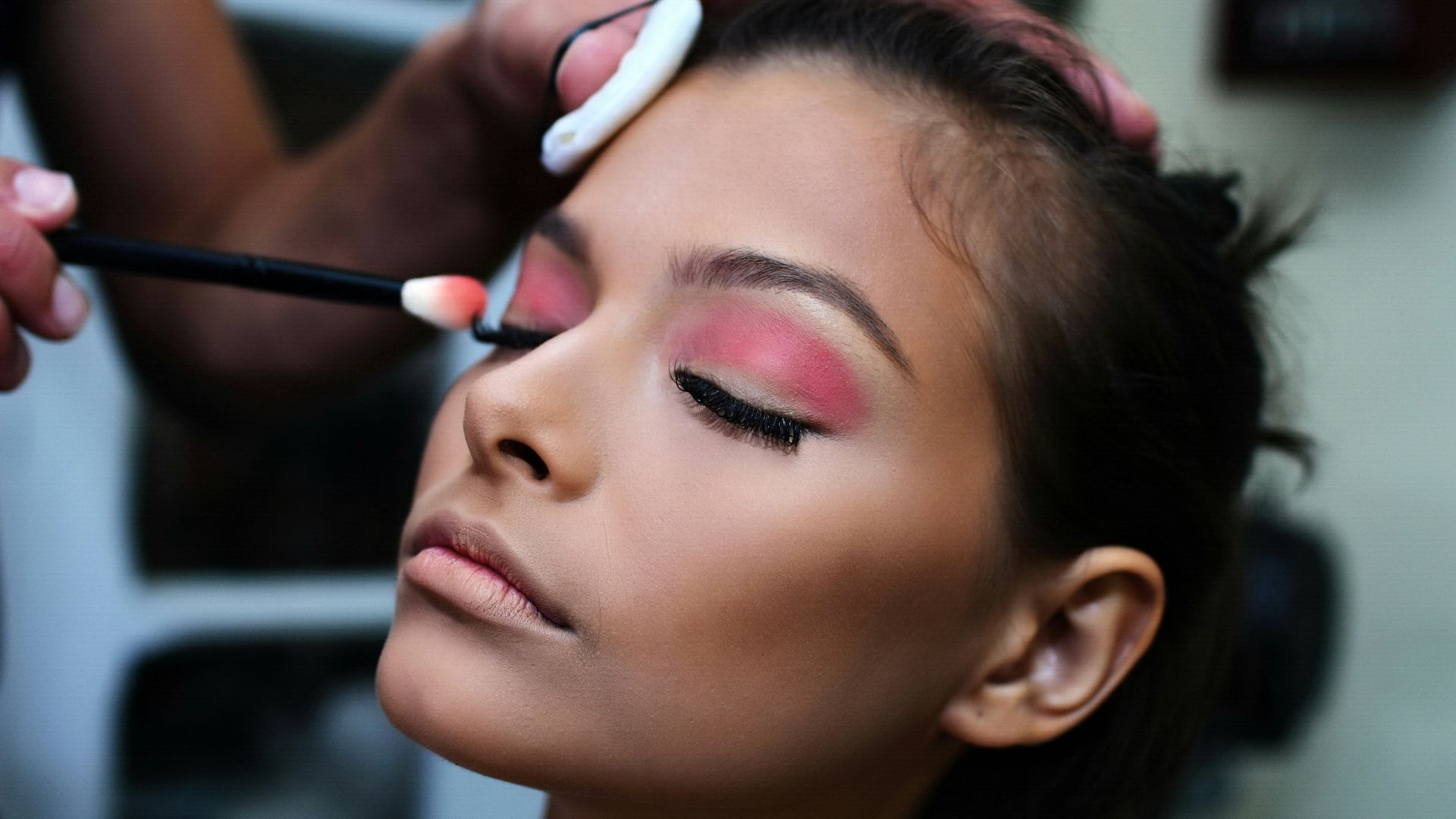 woman with pink lipstick holding white and purple toothbrush