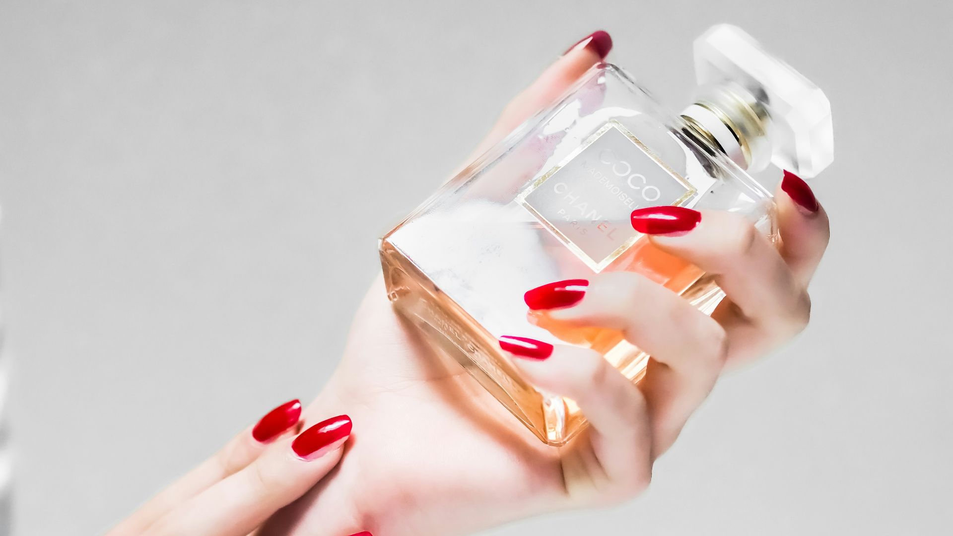 person holding clear glass bottle