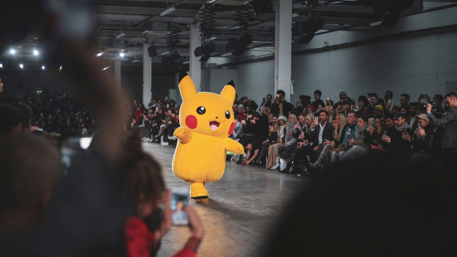 people in a concert with yellow pokemon pikachu mascot