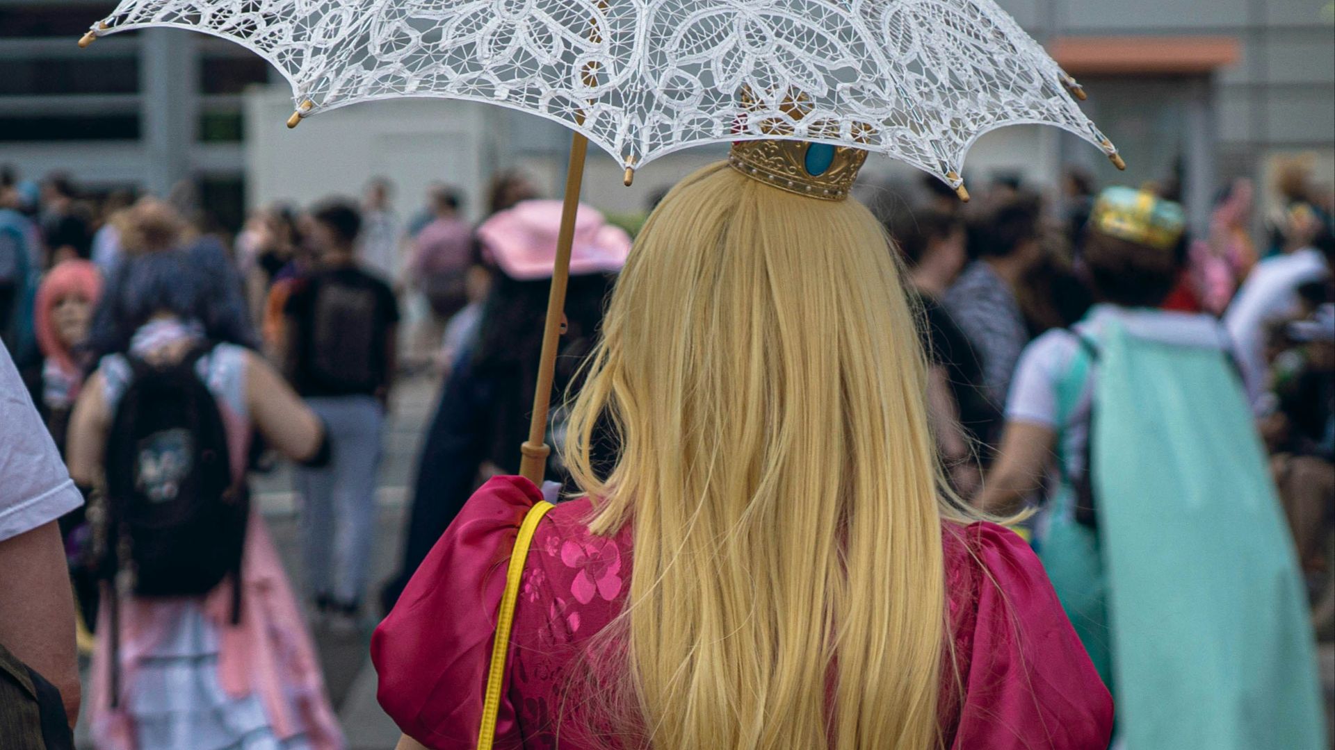 A woman in a pink dress holding an umbrella