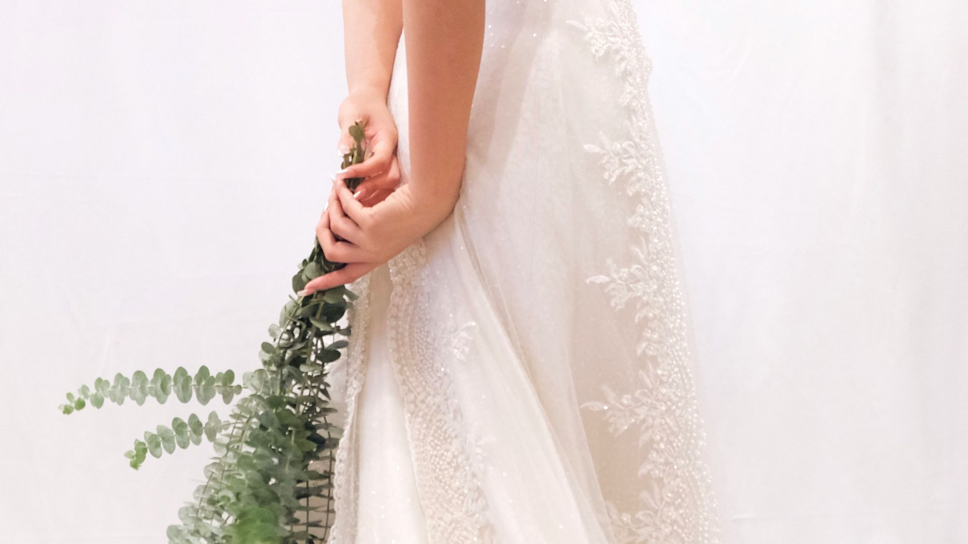 woman in white floral dress holding green plant