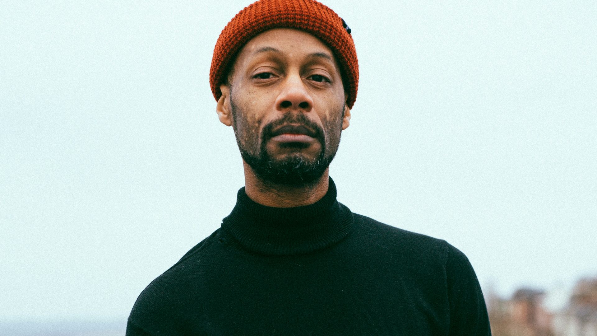 man wearing black sweater and red knitted cap