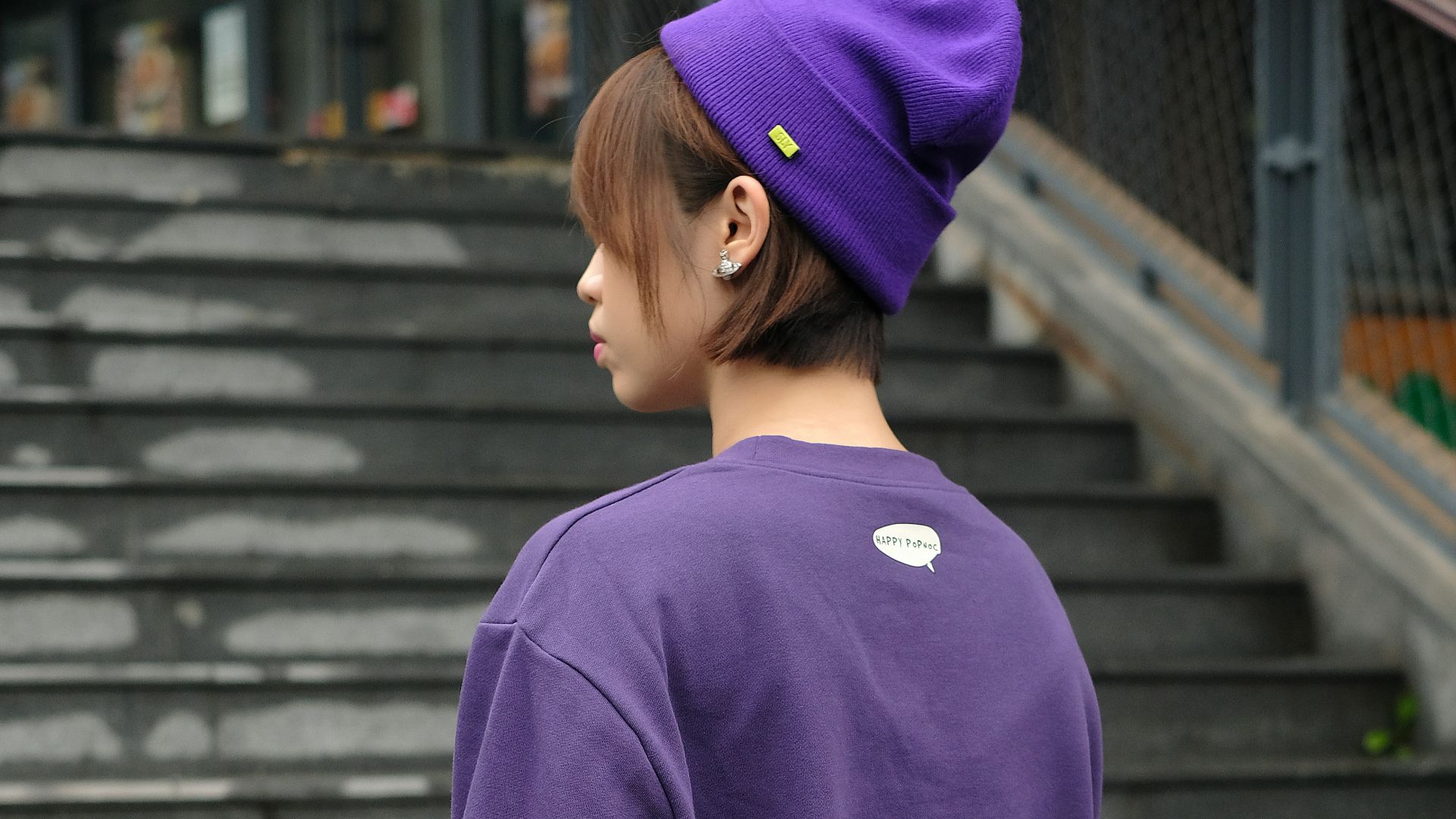 a woman wearing a purple sweatshirt and a purple hat