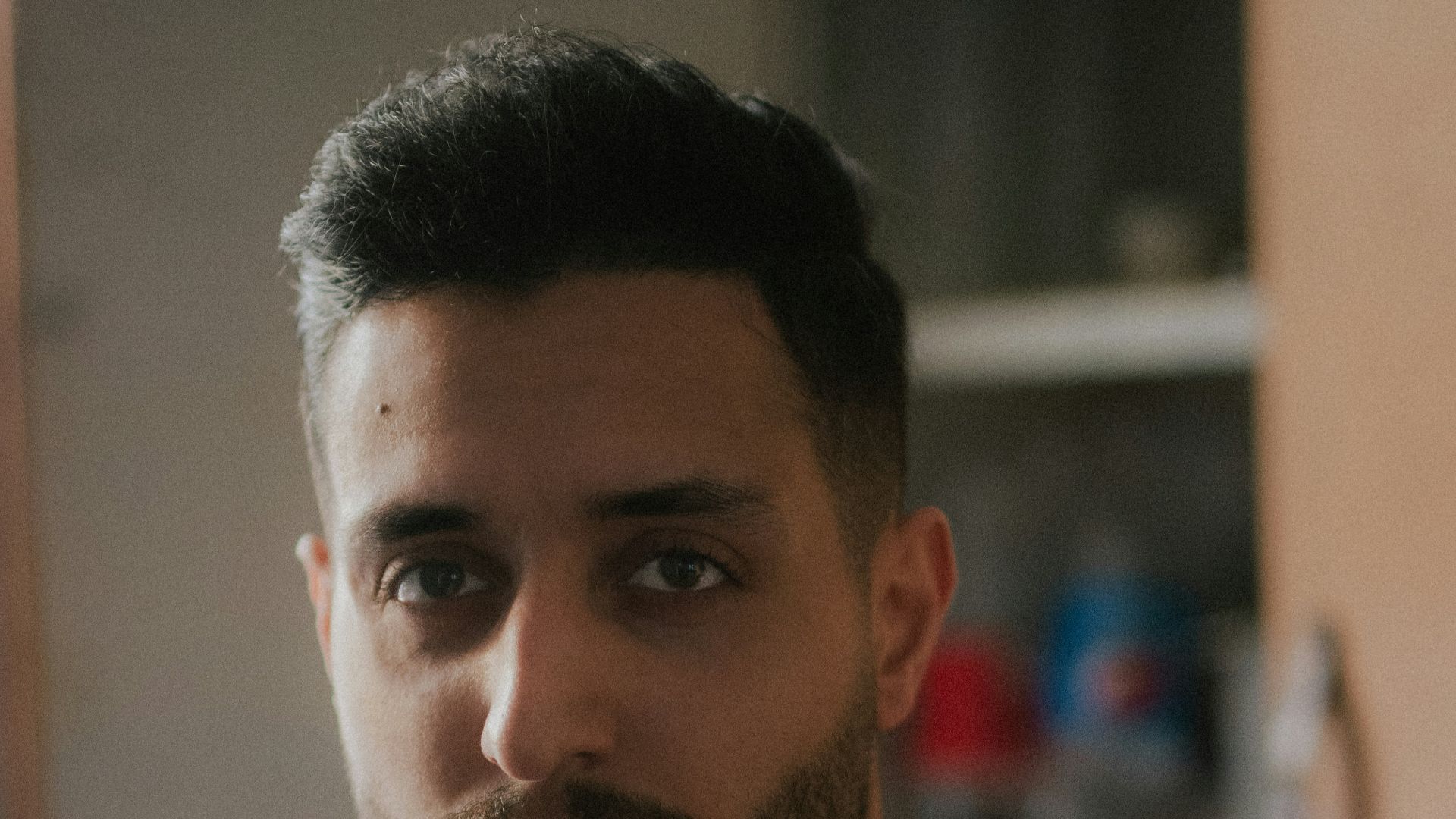 a man in a red shirt standing in a kitchen